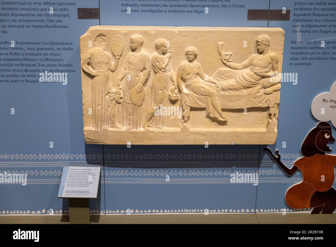 Copy of a votive relief from Piraeus. According to one opinion, it is a pretended dedication to Dionysus after a performance. 400 BC.Larissa, Greece. Stock Photo