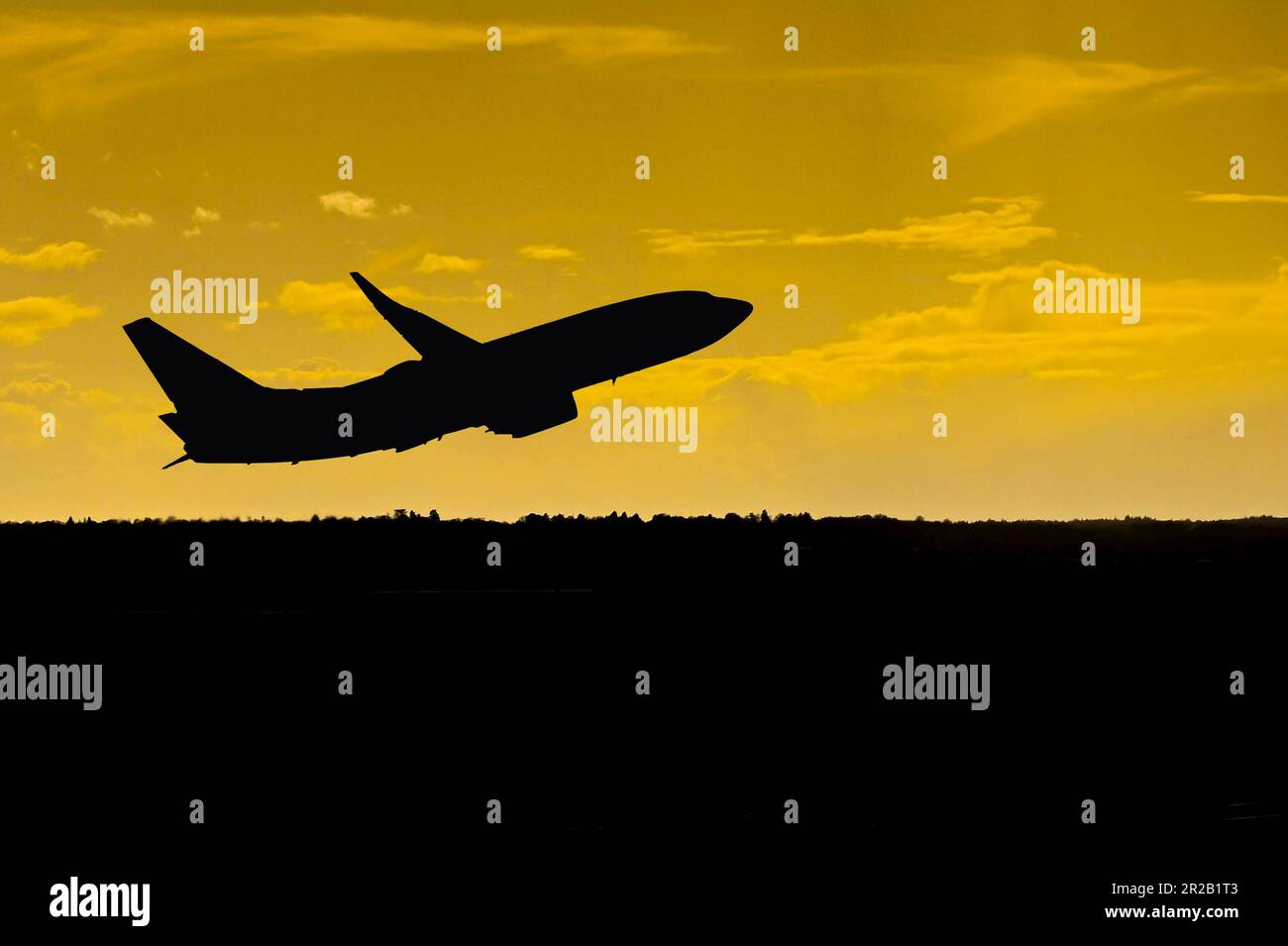 Silhouette of a passenger aircraft departing an airport at sunset. No people. Copy space. Stock Photo