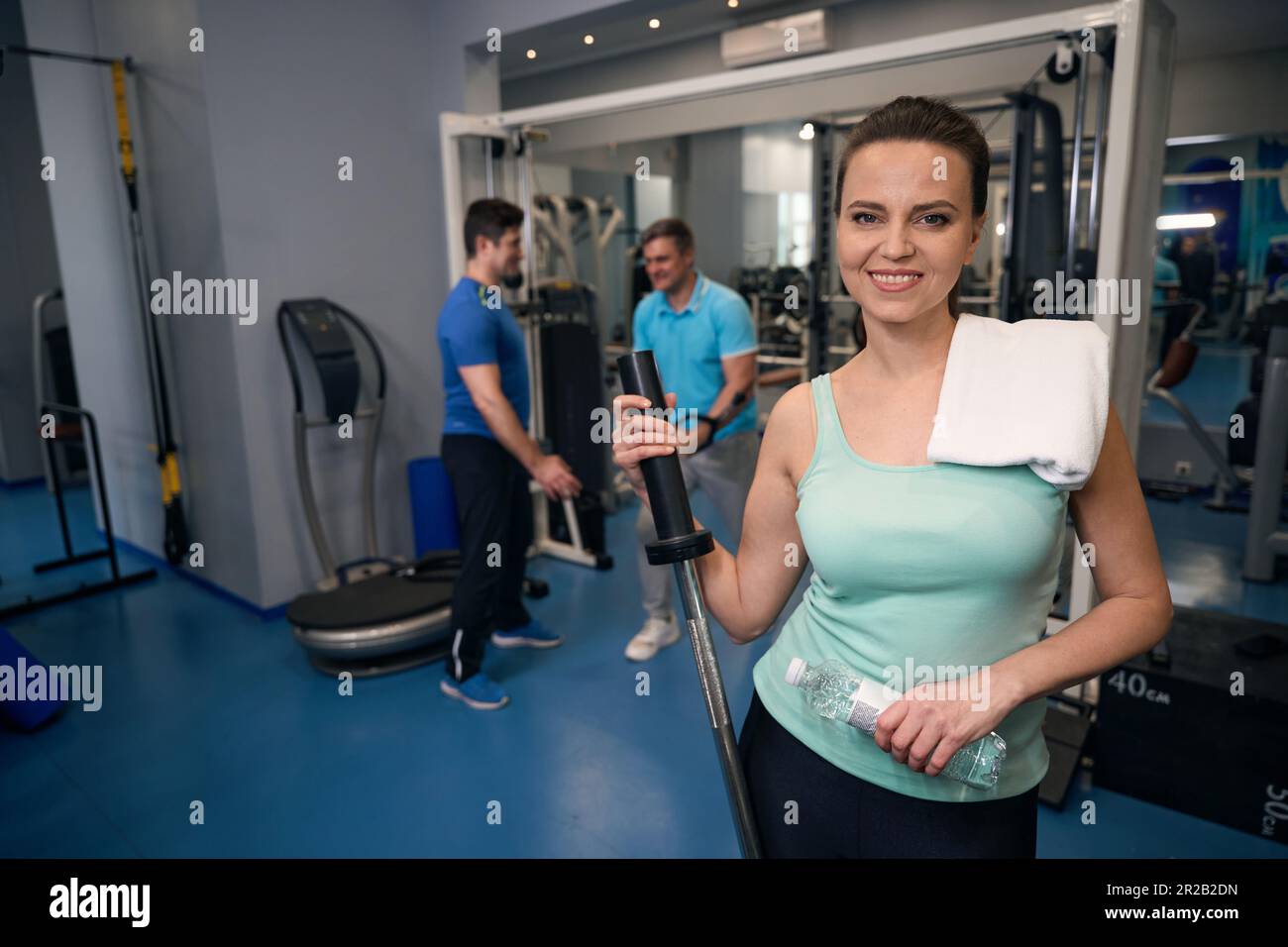 Joyous sportswoman posing for camera during strength training Stock Photo