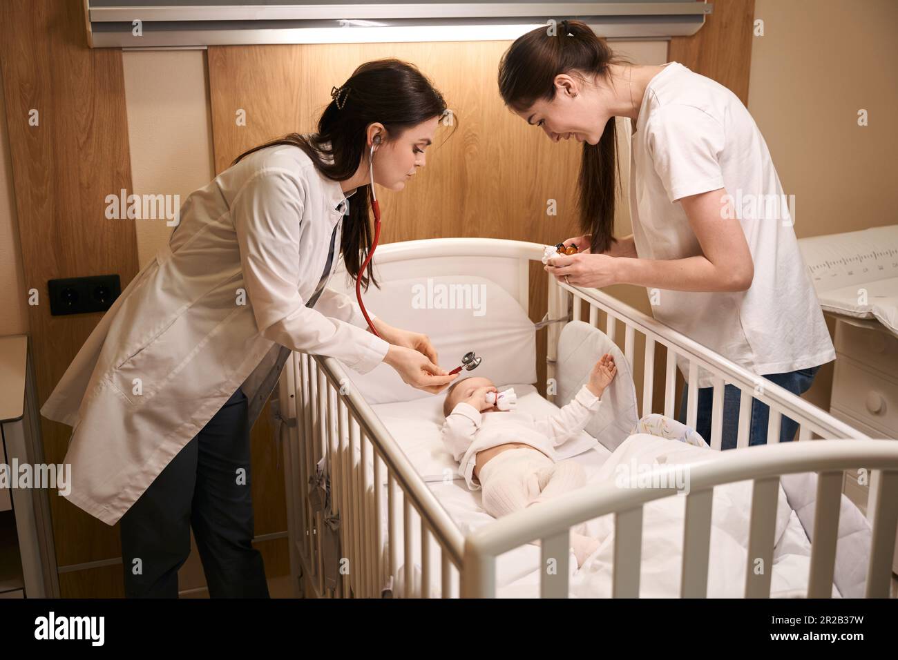 Serious pediatrician auscultating newborn baby in hospital ward Stock Photo Alamy