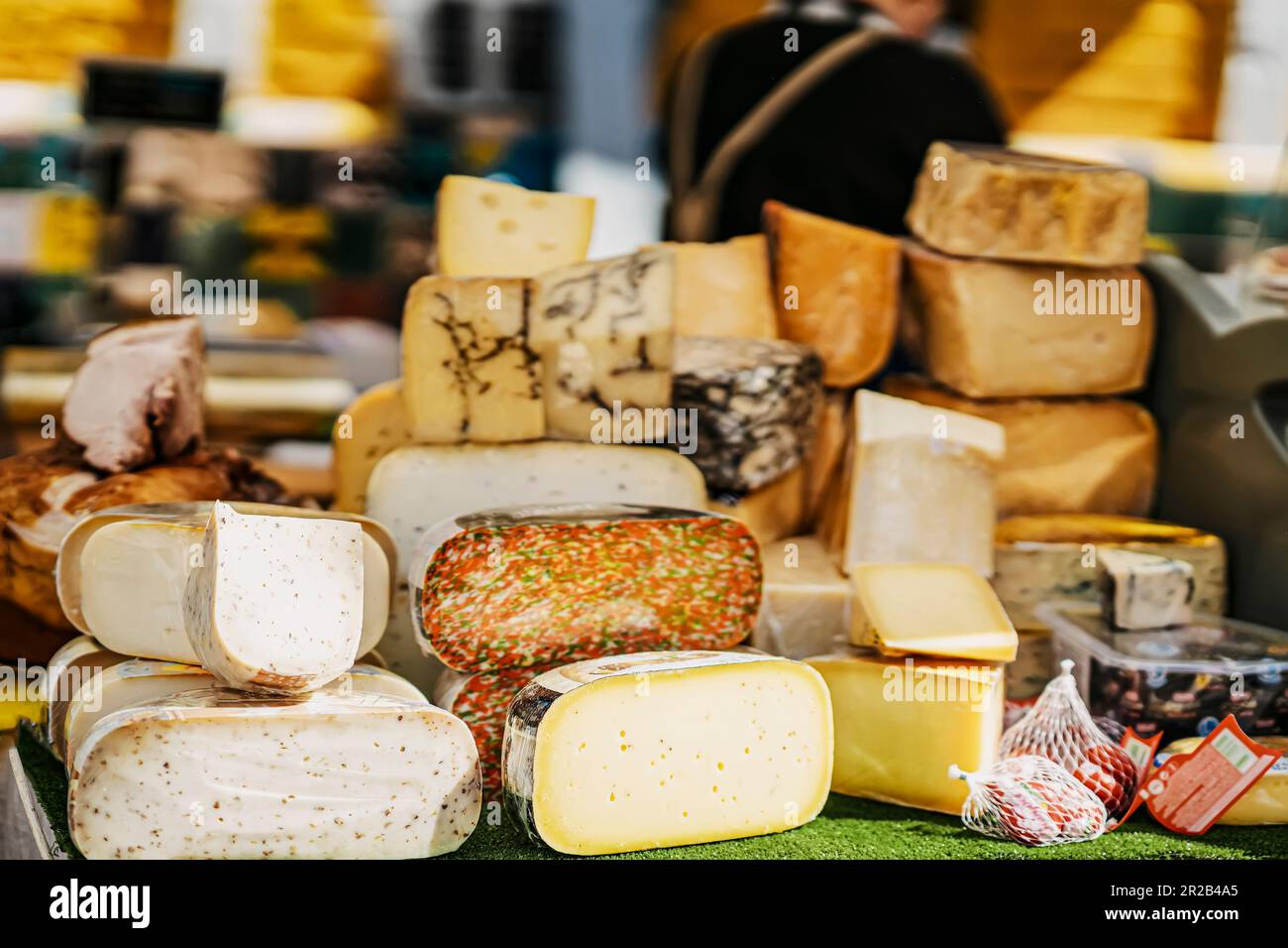 Cheese heads on market counter on market counter, different types and flavors. Gastronomic dainty products, real scene, food market Stock Photo