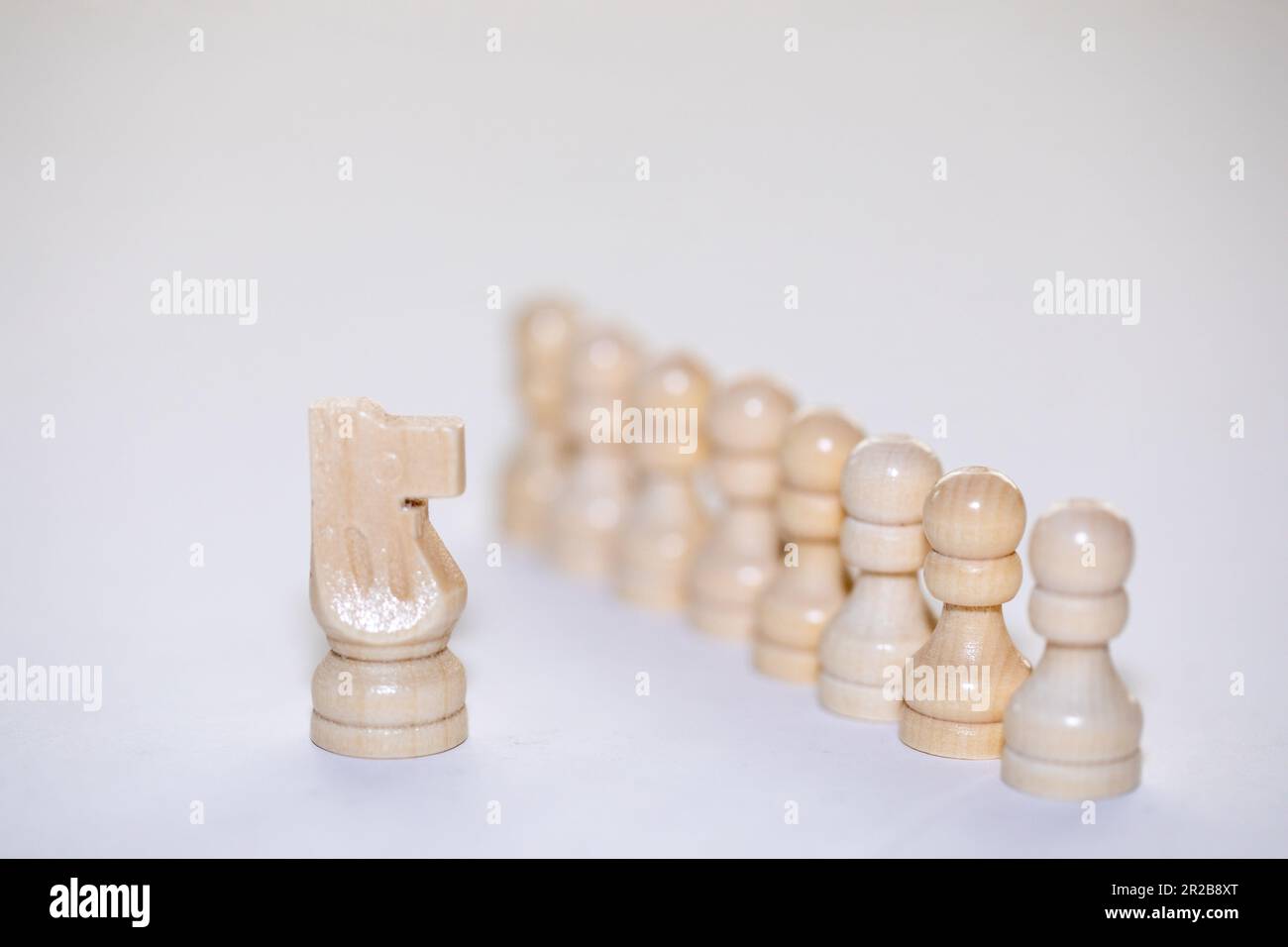 Chess Pieces, the Knight standing facing a row of pawns. high key ...