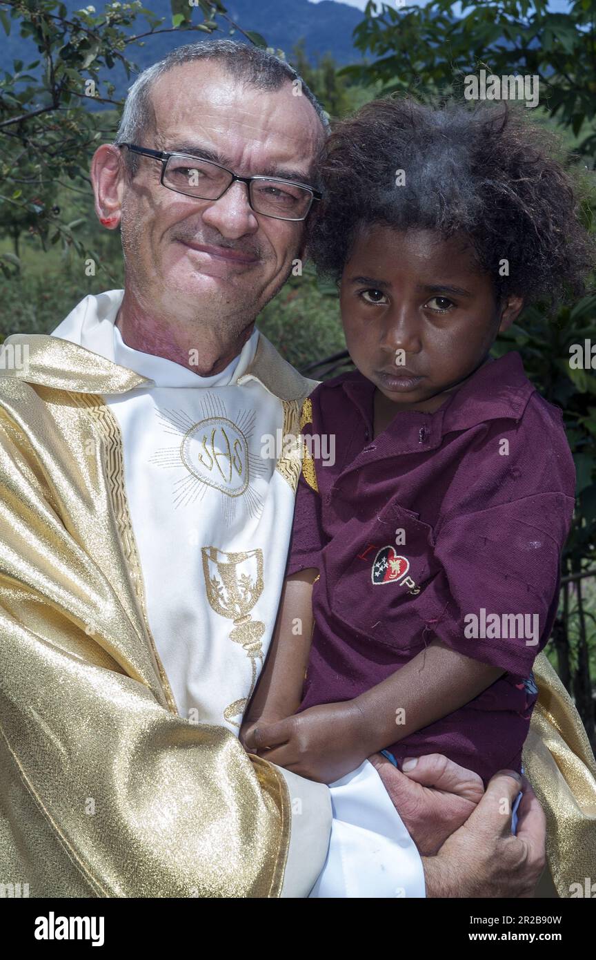 Papua New Guinea Eastern Highlands Goroka; white missionary holds a dark-skinned girl in his arms; Missionar hält ein kleines Mädchen in seinen Armen Stock Photo