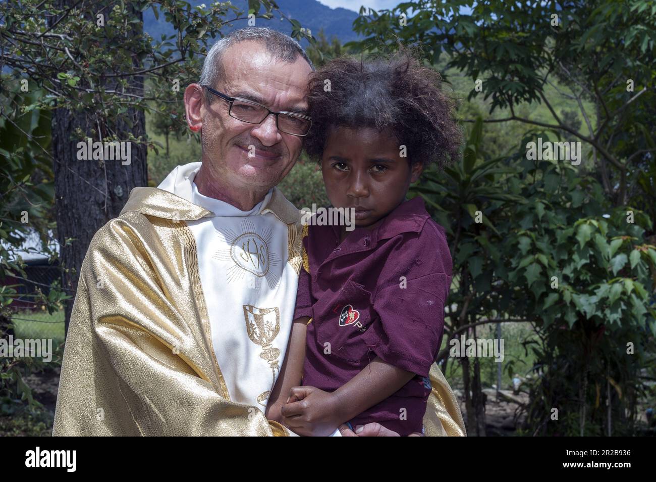Papua New Guinea Eastern Highlands Goroka; white missionary holds a dark-skinned girl in his arms; Missionar hält ein kleines Mädchen in seinen Armen Stock Photo