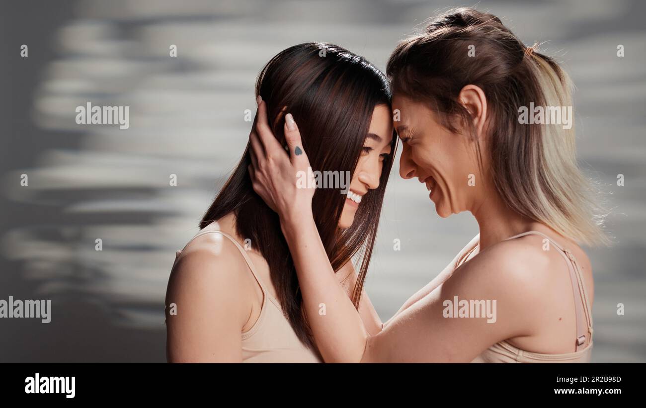 Beautiful natural women sharing hug in studio Stock Photo