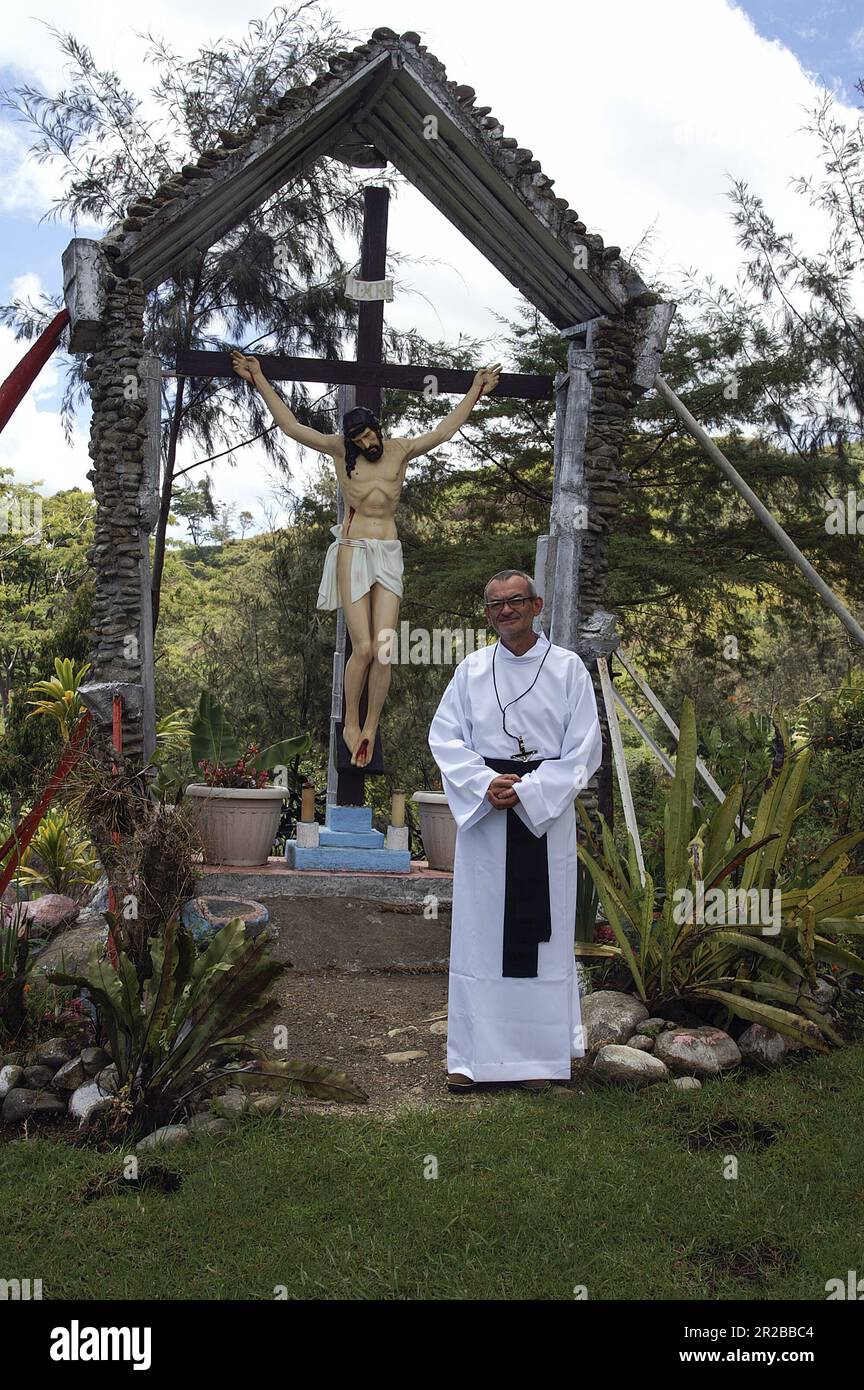 Papua New Guinea Eastern Highlands Goroka; missionary in a white robe by the cross in the garden; Missionar in einem weißen Gewand am Kreuz im Garten Stock Photo