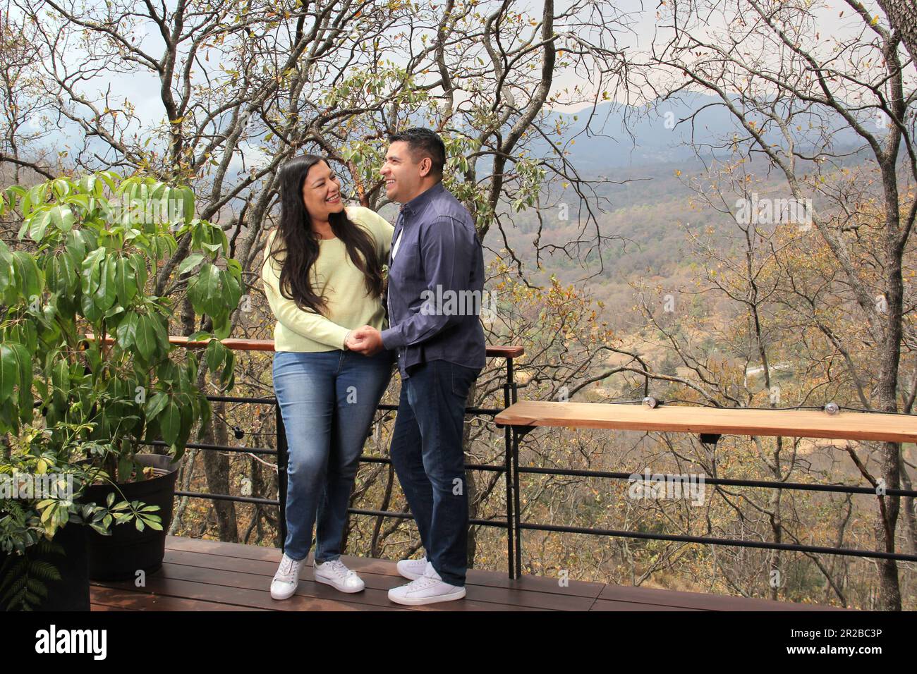 Forty-year-old adult Latino couple have a romantic getaway in a cabin in the middle of the woods to celebrate their love anniversary Stock Photo