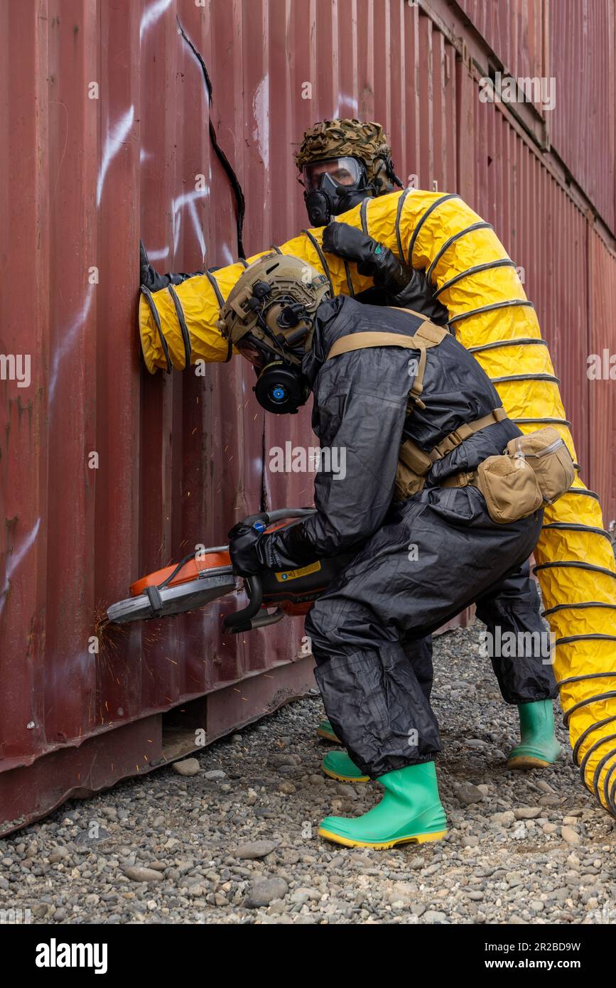 U.S. Marines with Headquarters Company, Chemical Biological Incident Response Force, saw through a shipping container and simultaneously pumping in fresh air while conducting a rescue scenario during exercise Arctic Edge 2023, Port MacKenzie, Alaska, May 15, 2023. Arctic Edge 2023 is a U.S. Northern Command-led exercise demonstrating the U.S. military's capabilities in extreme cold weather, joint force readiness and U.S. military and local homeland defense commitment to mutual strategic security interests in the Arctic region. (U.S. Marine Corps photo by Staff Sgt. Jacqueline A. Clifford) Stock Photo