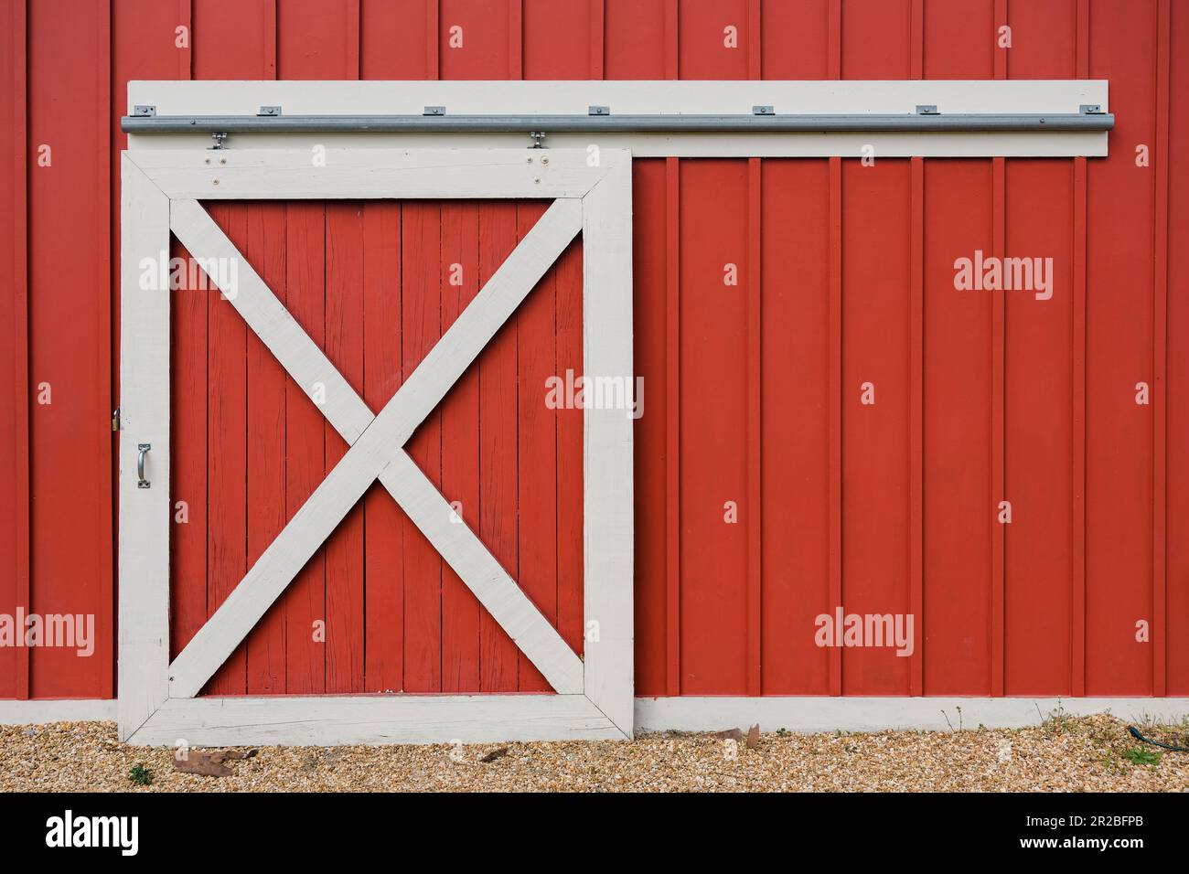 Common sliding red barn door with traditional red paint and cross
