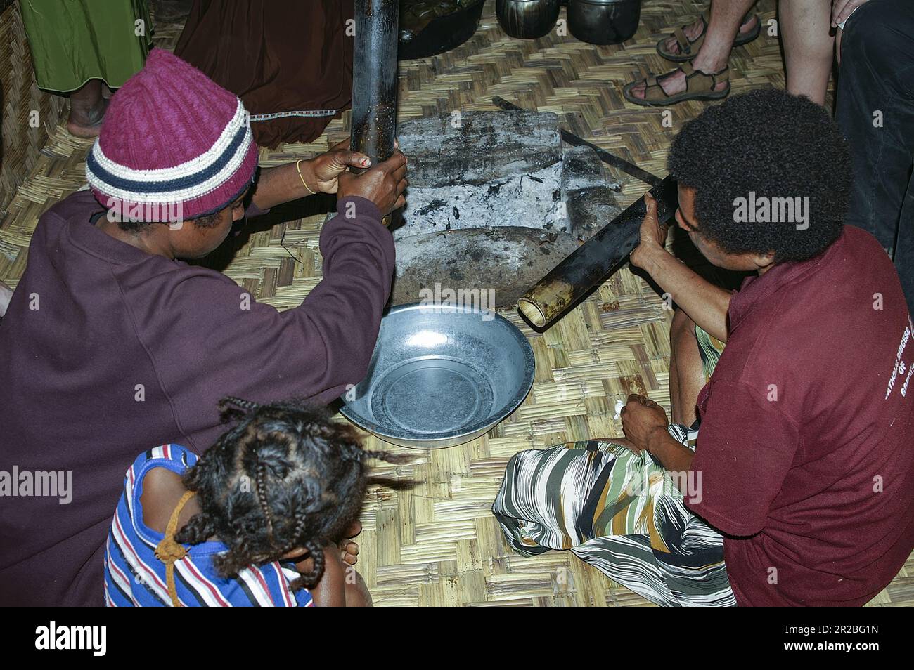 PNG, Papua New Guinea; Eastern Highlands; Goroka; Papuan women prepare a meal inside a hut; Papua-Frauen bereiten in einer Hütte eine Mahlzeit zu Stock Photo
