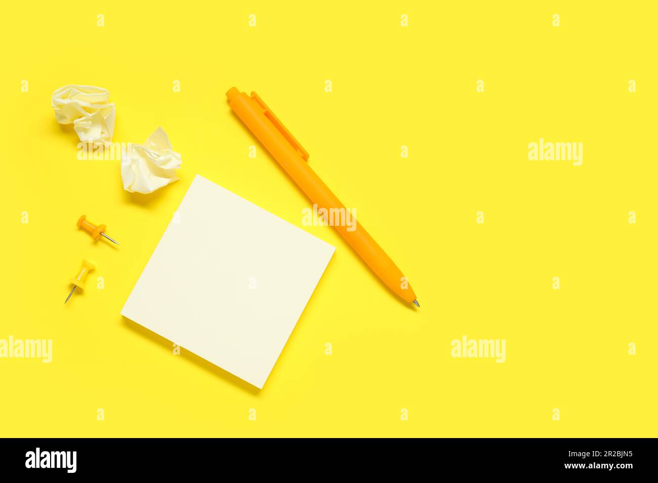 Pen with sticky notes and pins on yellow background Stock Photo