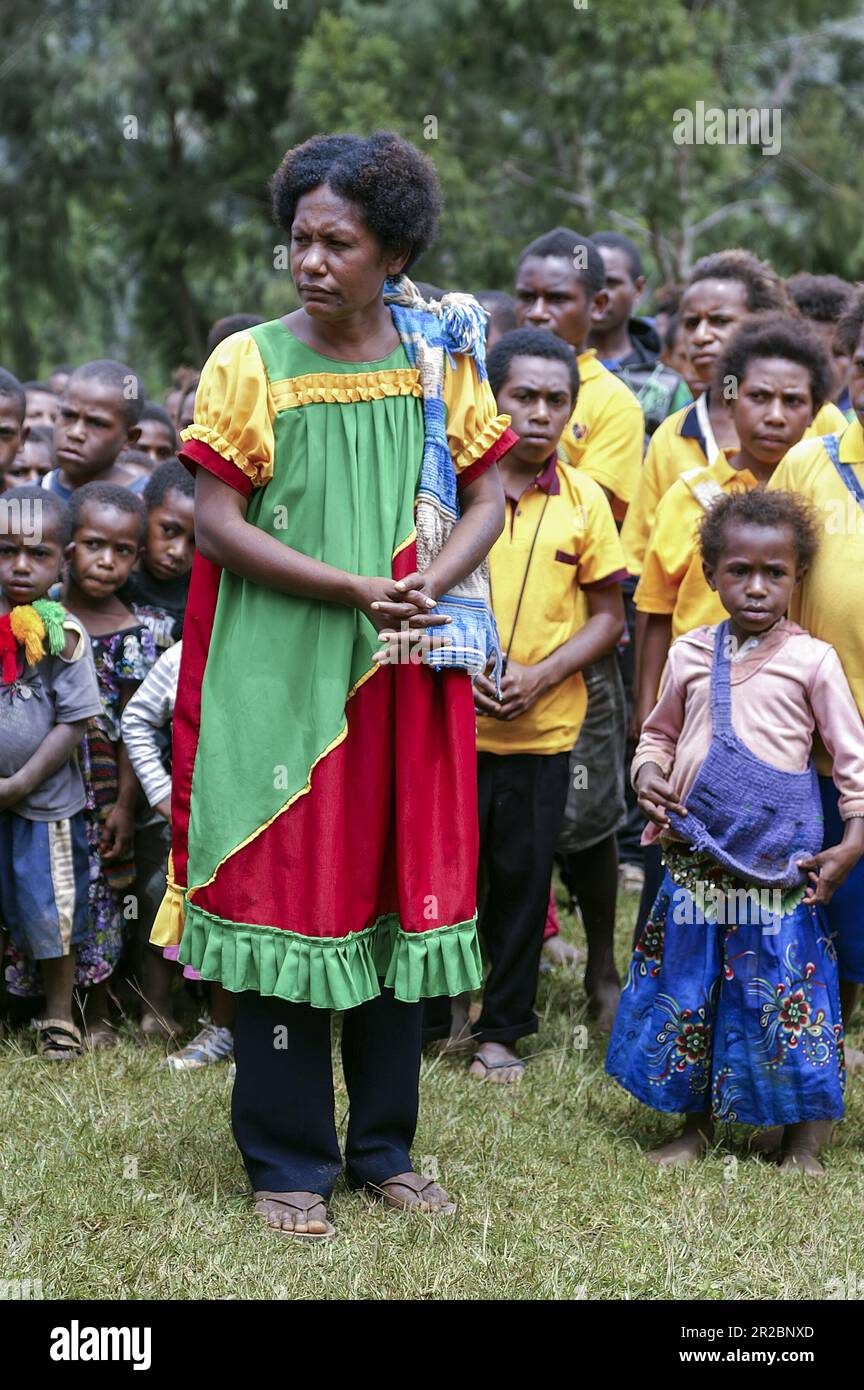 Papua New Guinea; Eastern Highlands; Goroka; A Papuan girl in a dress in national colors (yellow, green, red). Papua-Frau in den Nationalfarben Stock Photo