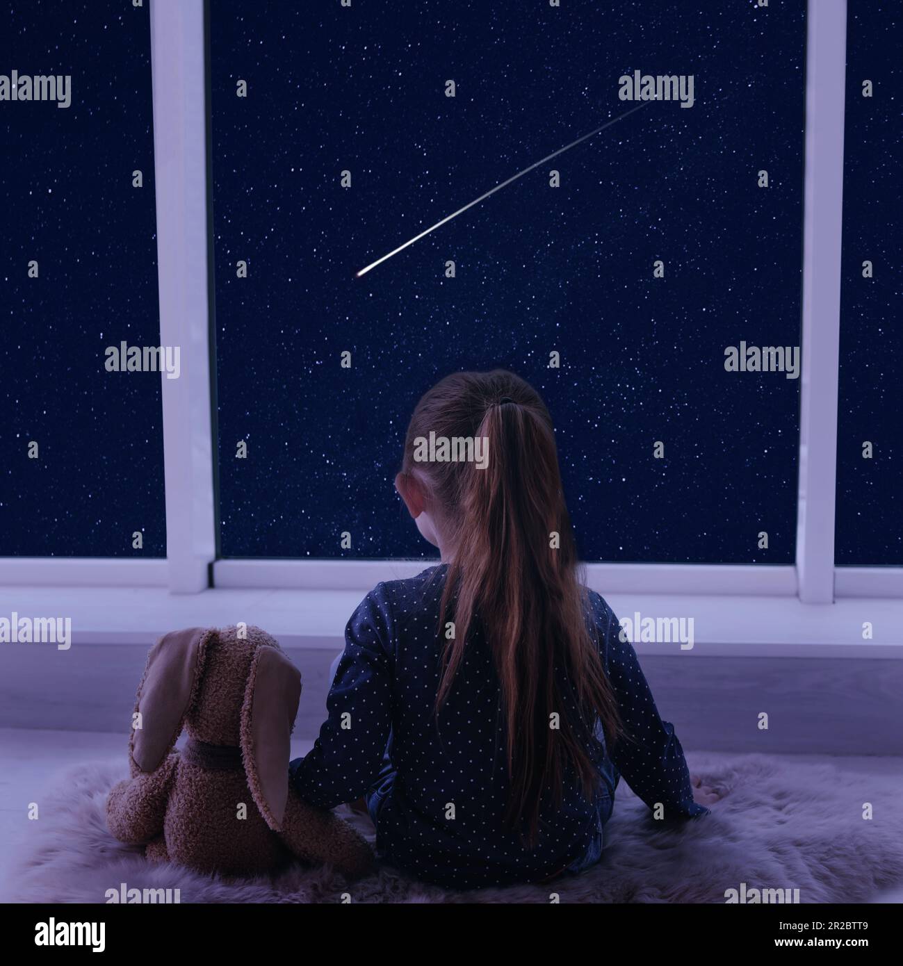 Little girl near window looking at shooting star in beautiful night sky ...