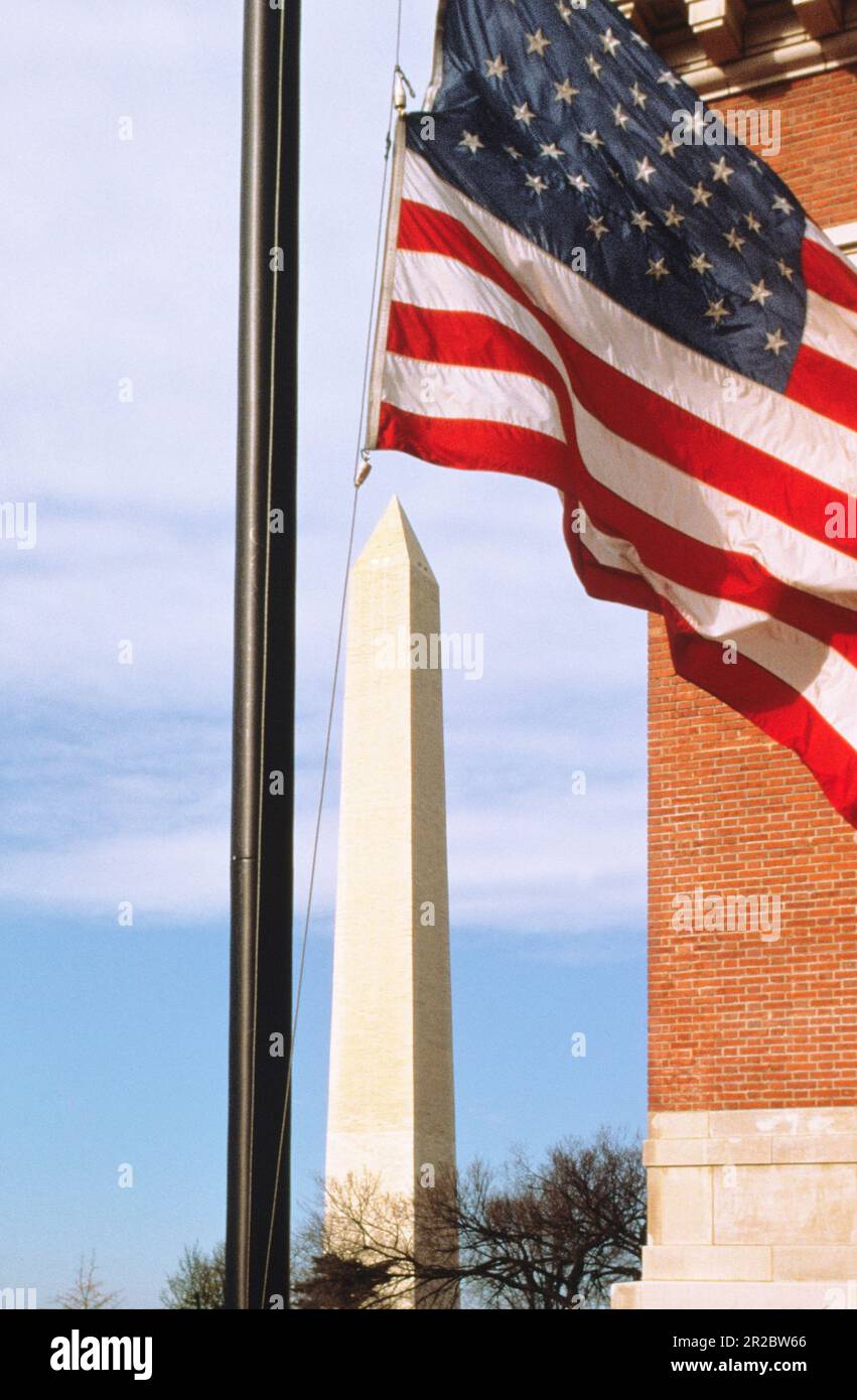 Washington Monument and American flag flying in front of Holocaust Museum on the National Mall.  Raoul Wallenberg Place in Washington DC USA Stock Photo