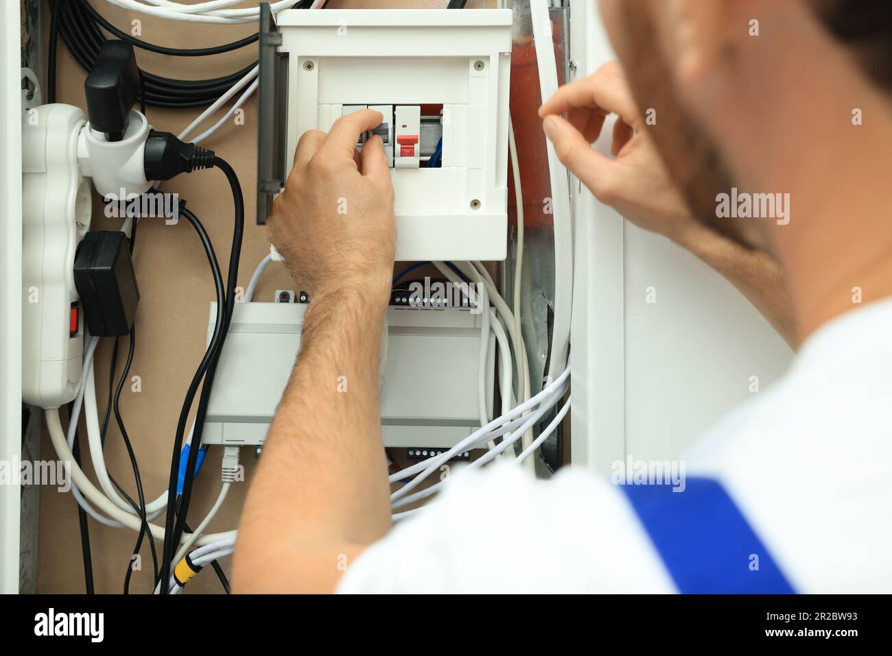 Electrician switching off circuit breakers in fuse box, closeup Stock