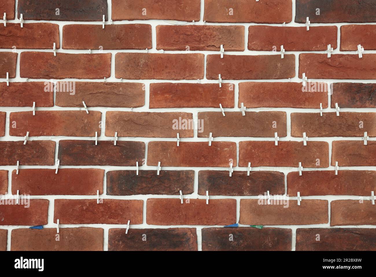 Decorative bricks with tile leveling system on wall Stock Photo