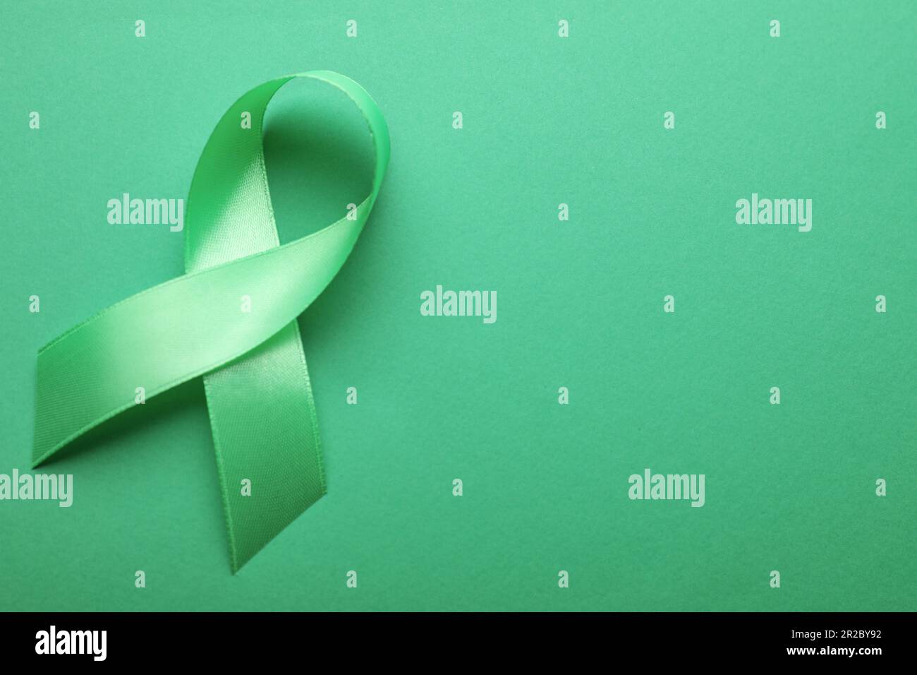 World Mental Health Day. Green ribbon on color background, top view ...