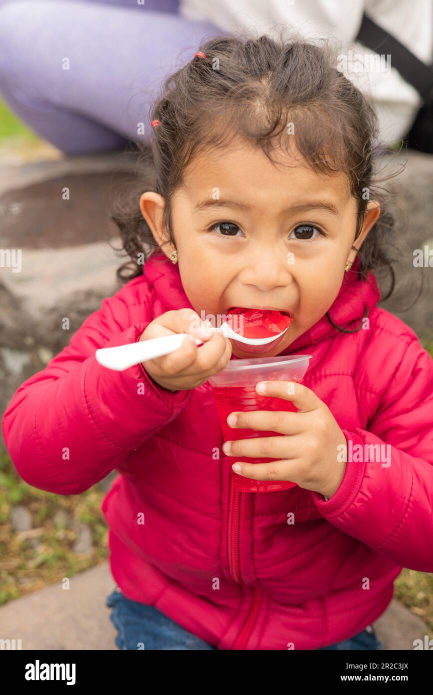 beautiful little girl eating delicious jelly wear casual clothes