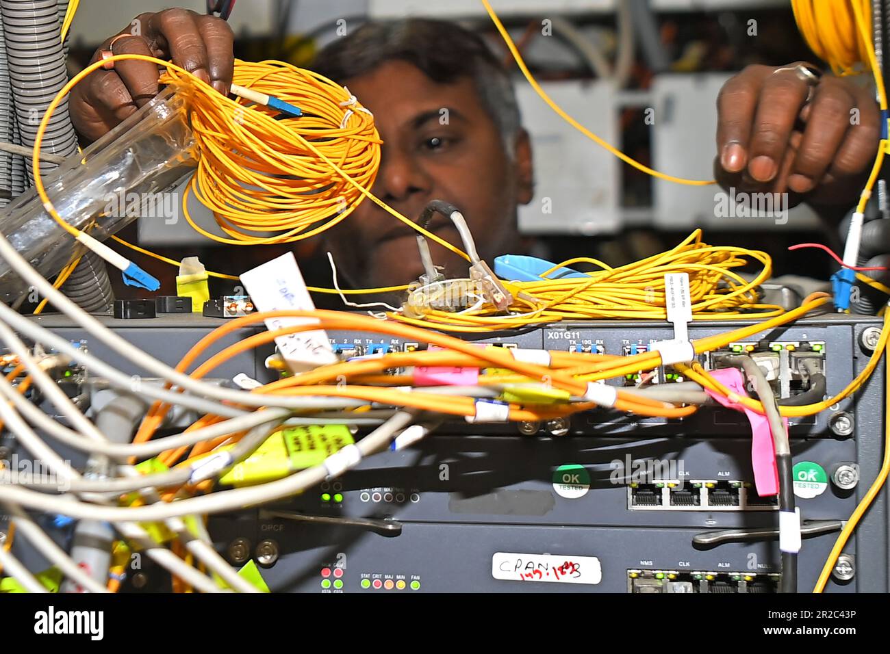 A telecom engineer checks the network link at the transmission room of BSNL Telephone Exchange office at Agartala. May 17th is the anniversary of the signing of the first International Telegraph Convention and the creation of the International Telecommunication Union (ITU). According to the United Nations, World Telecommunication Day has been celebrated annually since 1969. Agartala, Tripura, India. Stock Photo