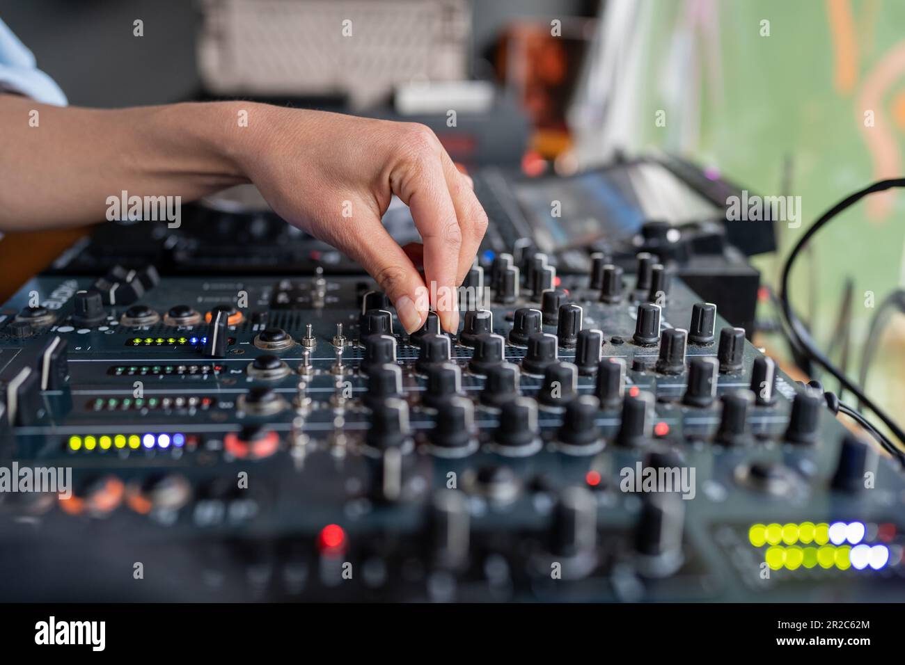 Woman radio DJ plays music at radio station studio on mixing console