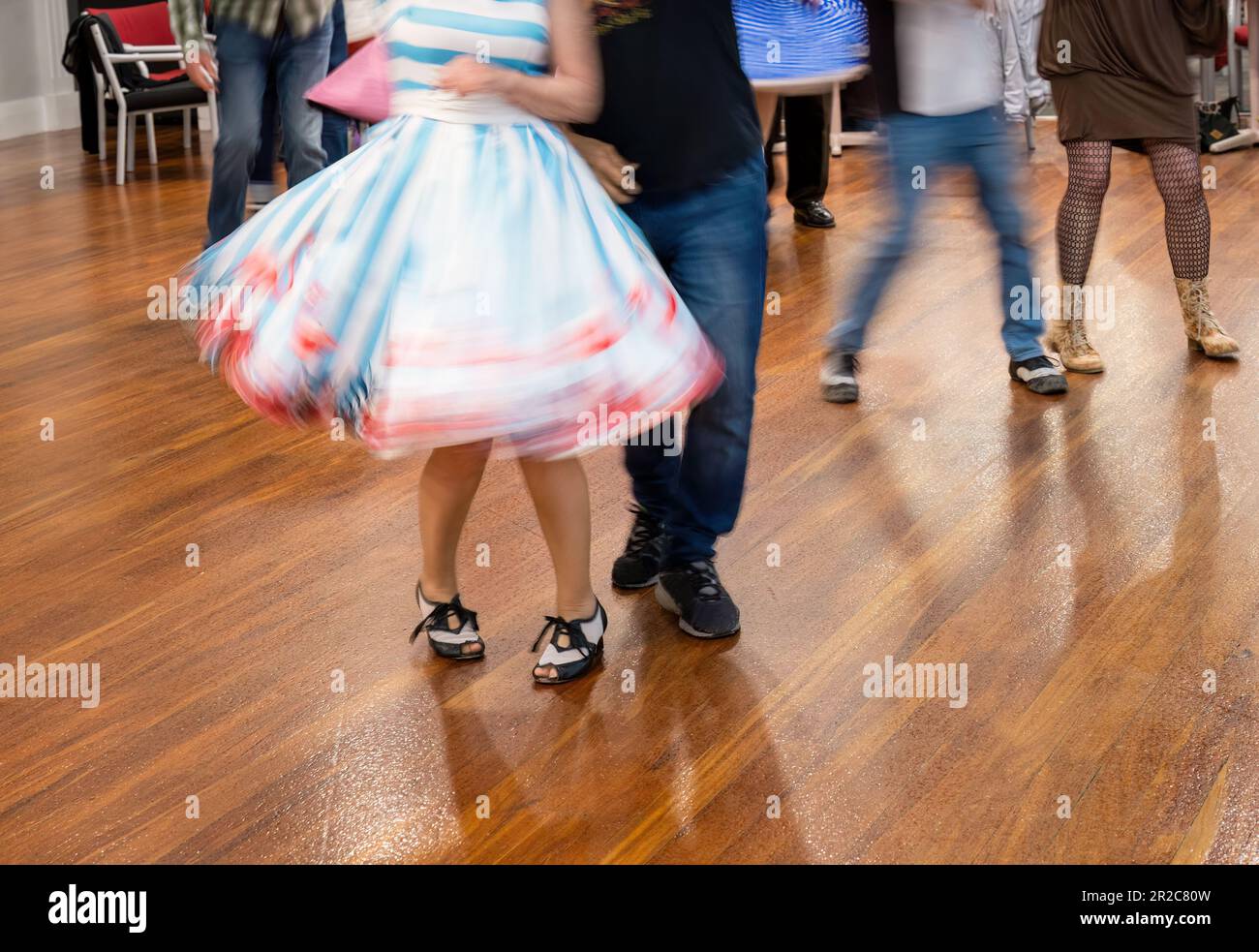 People enjoying dancing at a dance club. Motion blur of beautiful flying skirt captured in camera by using slow shutter speed. Stock Photo