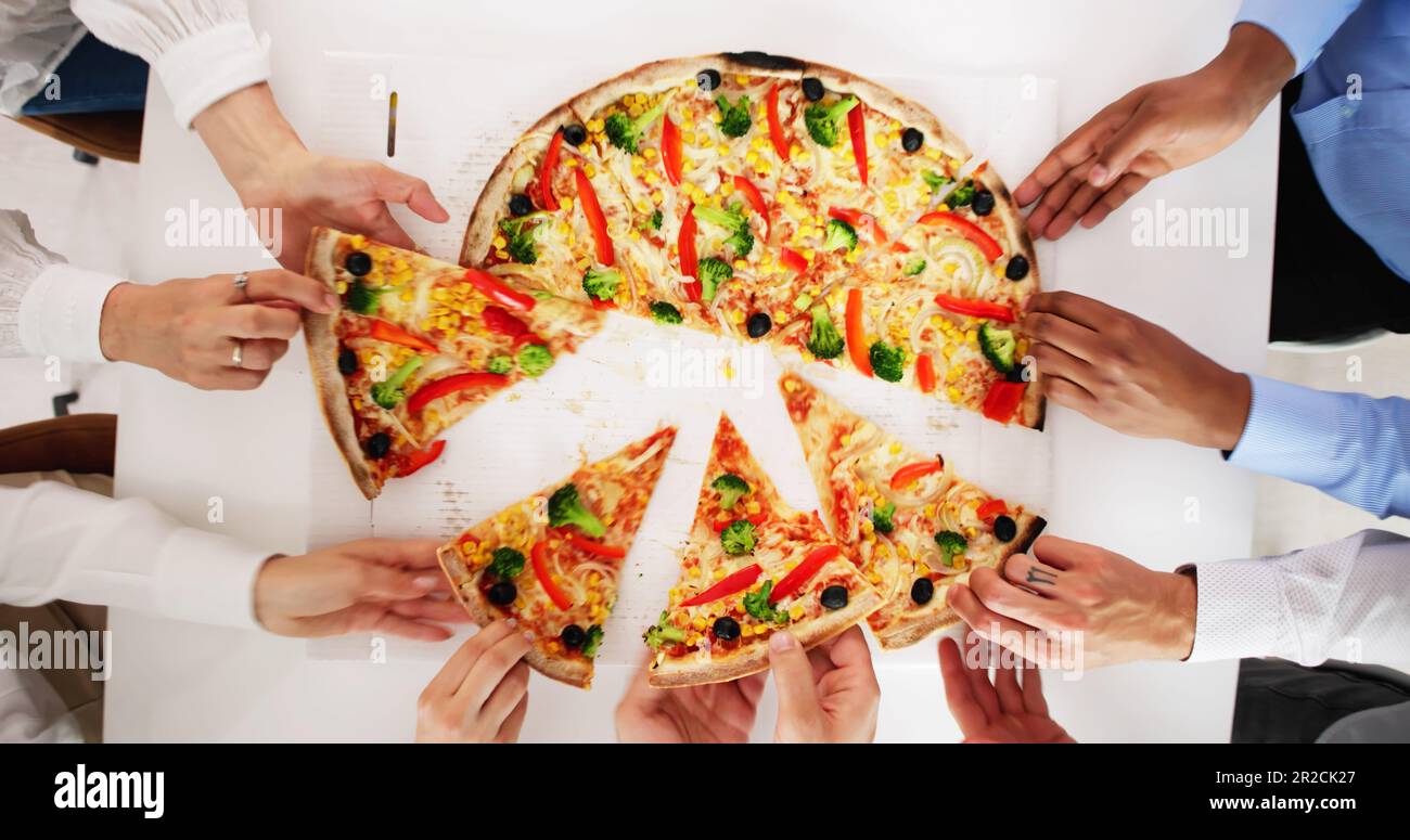 Friends Eating Pizza At Office Table Indoors Stock Photo