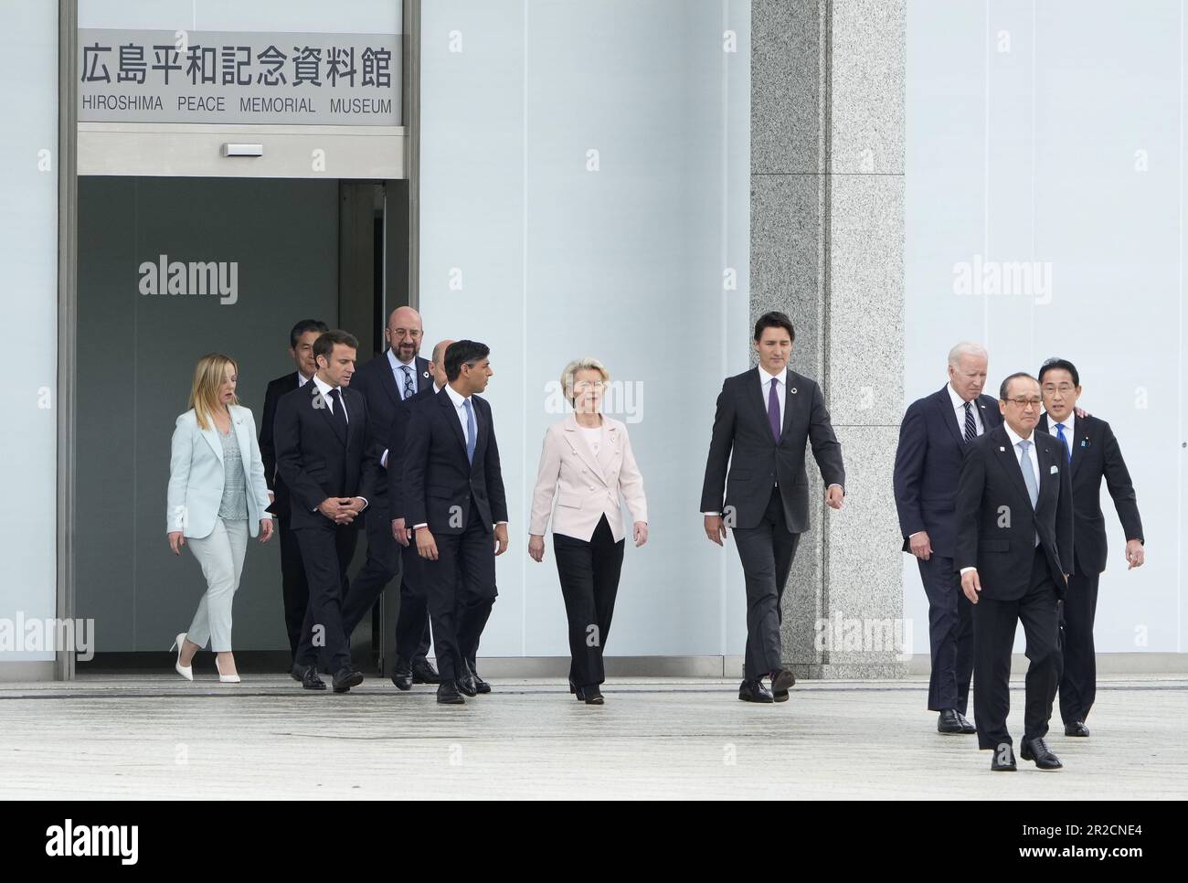 May 19, 2023, Hiroshima, Japan: (L-R) Italian Prime Minister Giorgia Meloni, an unidentified official, French President Emmanuel Macron, European Council President Charles Michel, German Chancellor Olaf Scholz, British Prime Minister Rishi Sunak, European Commission President Ursula von der Leyen, Canadian Prime Minister Justin Trudeau, US President Joe Biden, Mayor of Hiroshima Kazumi Matsui and Japan's Prime Minister Fumio Kishida walk out of the Peace Memorial Museum to a flower wreath laying ceremony in the Peace Memorial Park as part of the G7 Hiroshima Summit in Hiroshima, Japan, 19 May Stock Photo