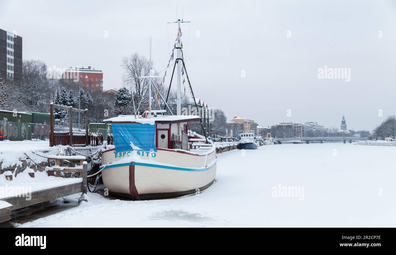 Turku, Finland - January 17, 2016: Vintage white boat is moored at river coast on a winter day Stock Photo