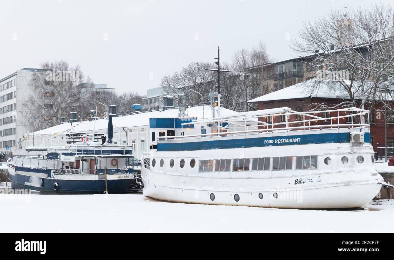 Turku, Finland - January 17, 2016: Floating restauraunt on vintage white boat moored at river coast Stock Photo