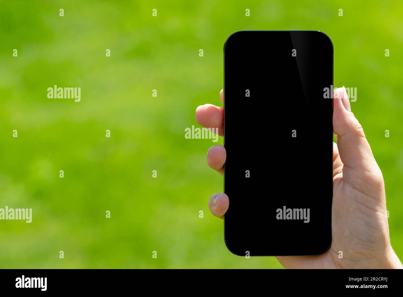 Blank black screen smartphone in woman's hand, perfect design mockup