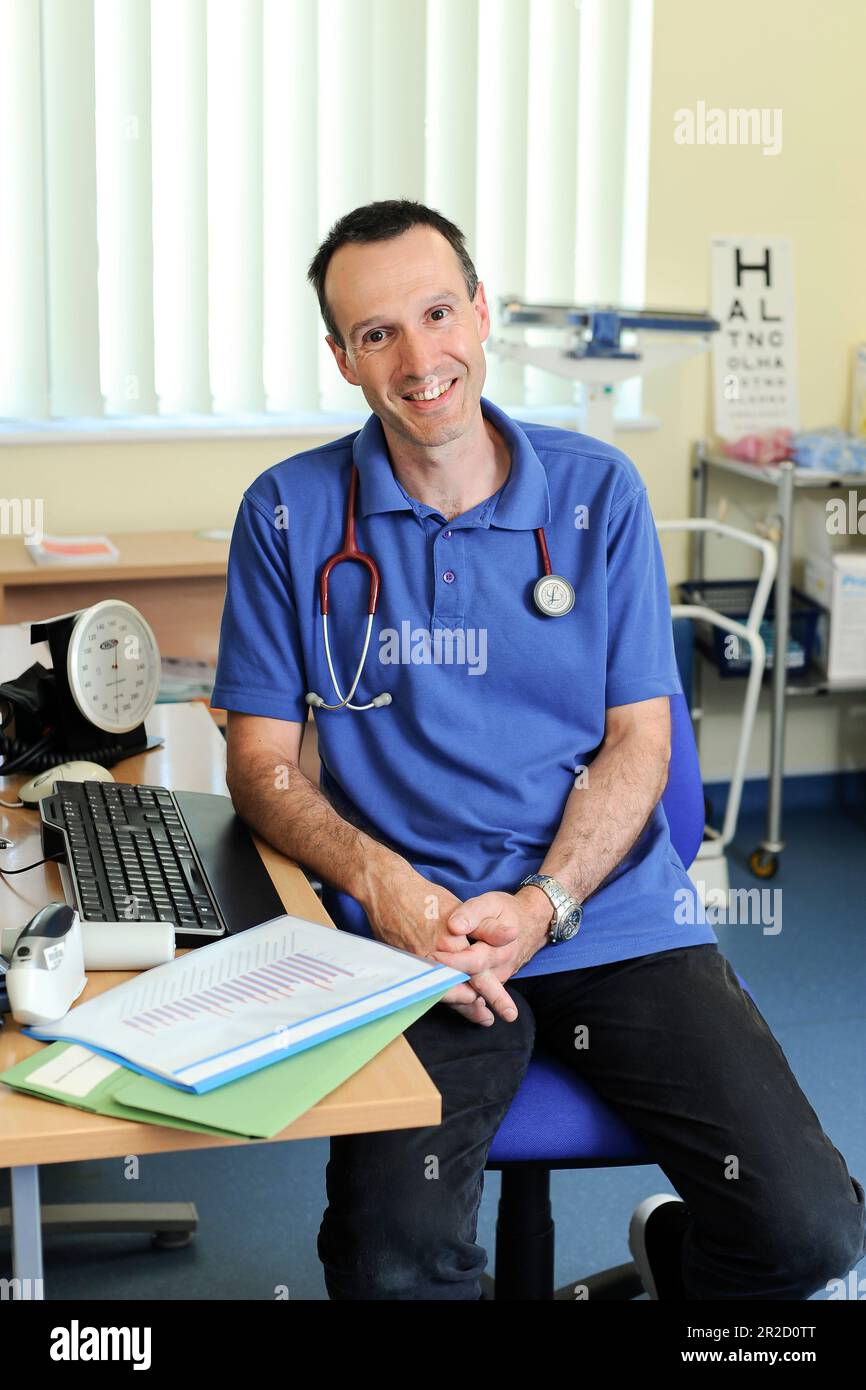 A NHS GP Doctor pictured in his general surgery. North Devon England UK ...