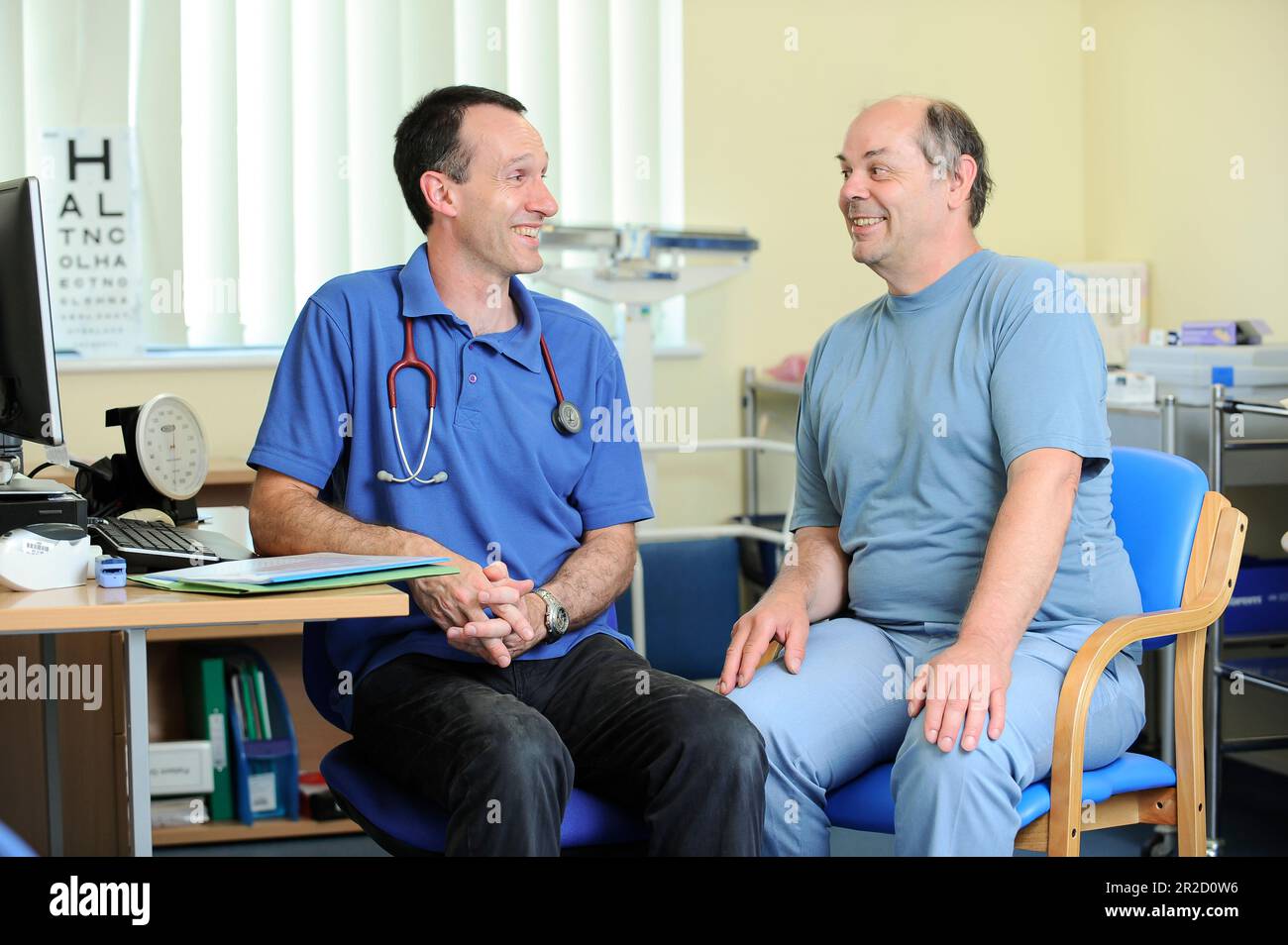 A NHS GP Doctor pictured with one of his patients at a general surgery in North Devon England UK Stock Photo