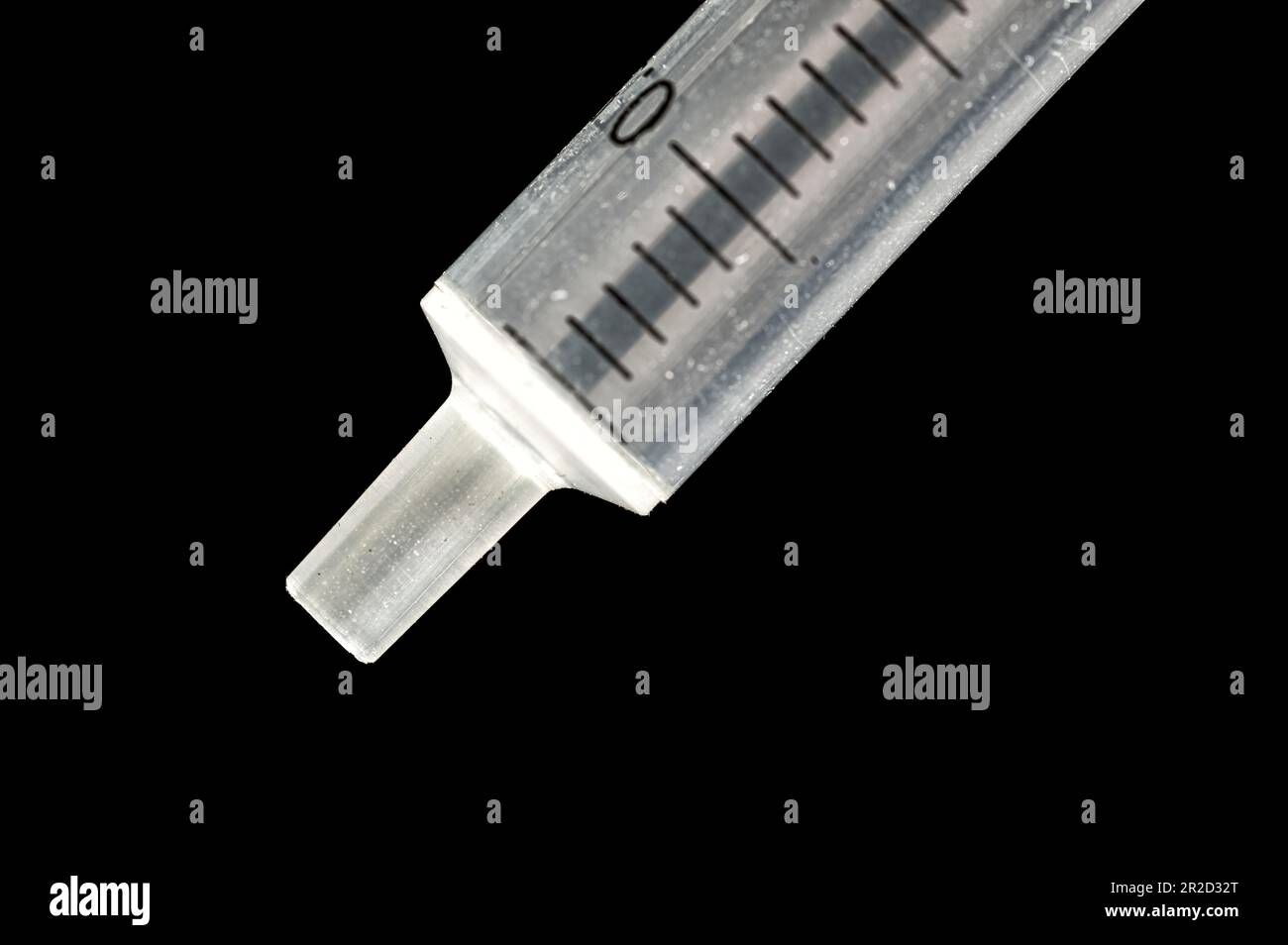 Mouth of a syringe without a needle in extreme macro on a black background Stock Photo