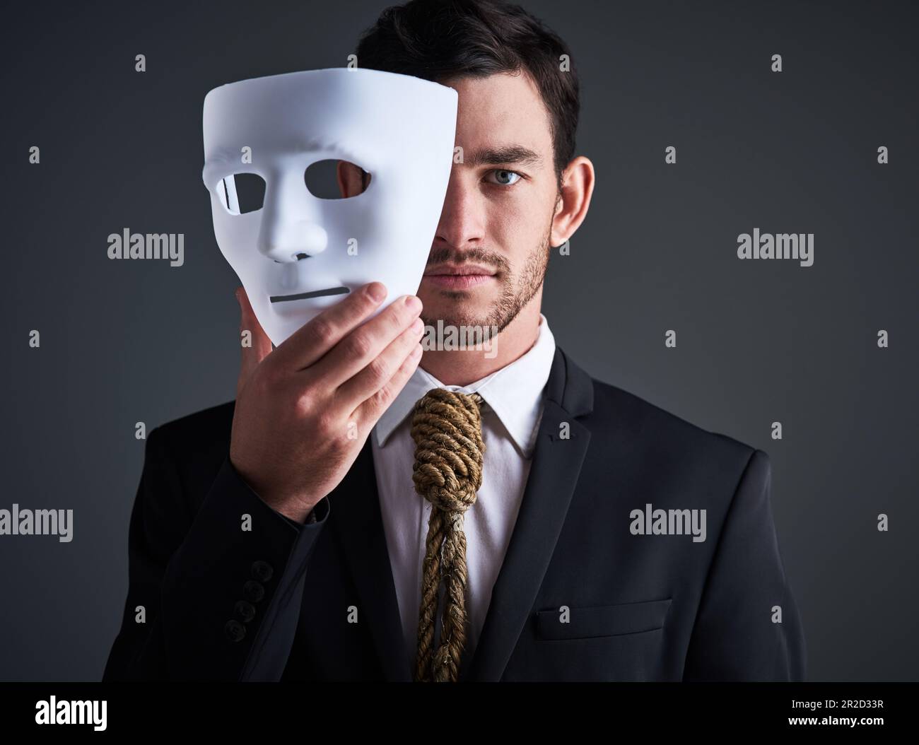 Two faced portrait, mask and fake businessman in a studio with serious ...