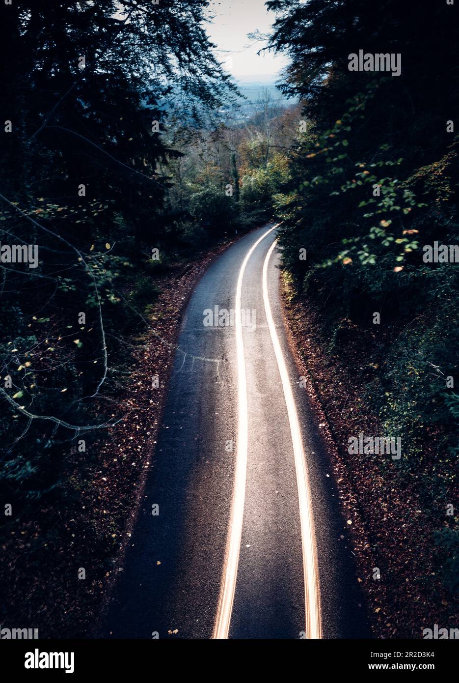 long exposure of car driving with headlights through mountain pass Stock Photo