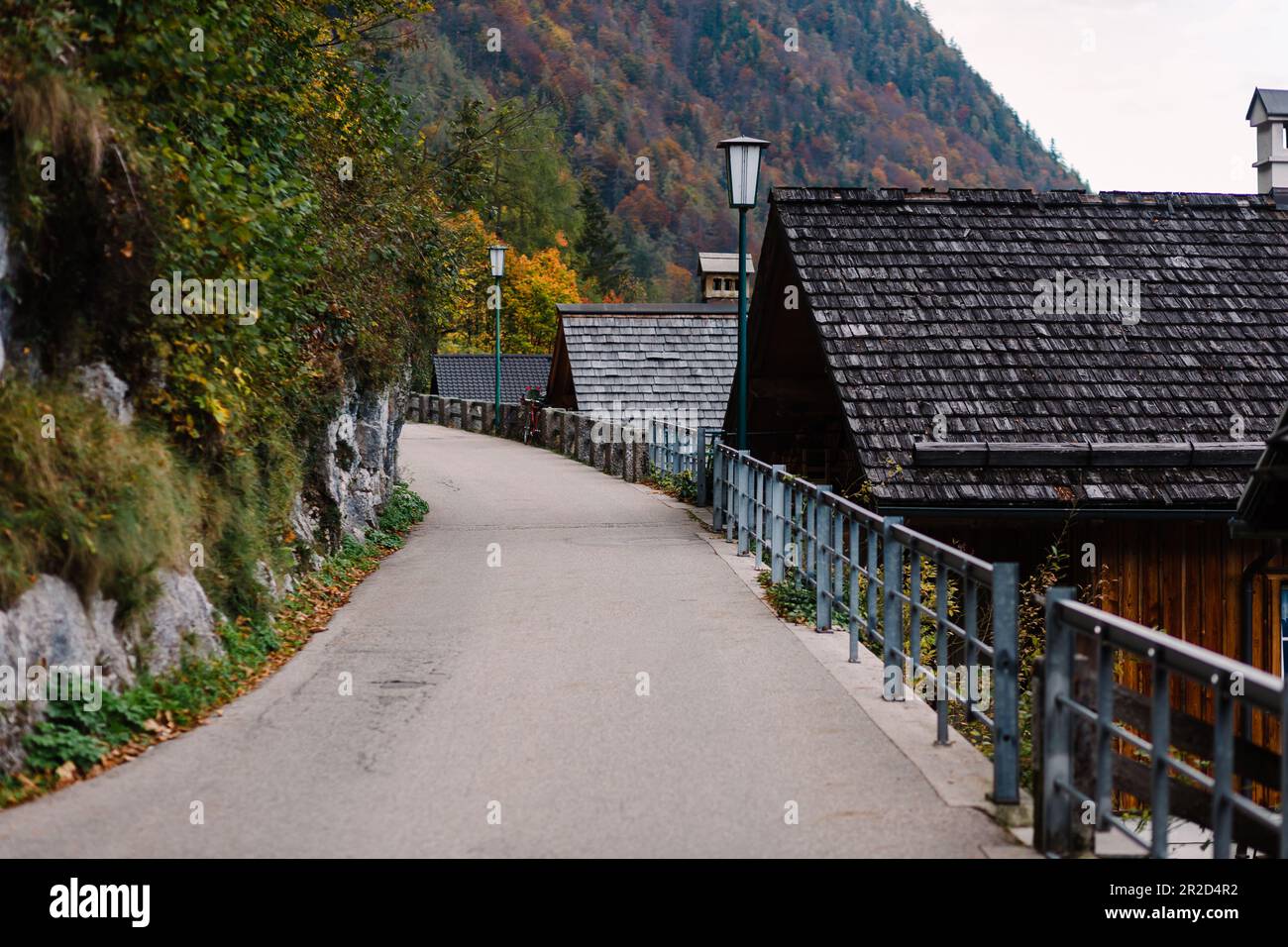 empty street surrounded by wooden houses and Alpine mountains Stock Photo
