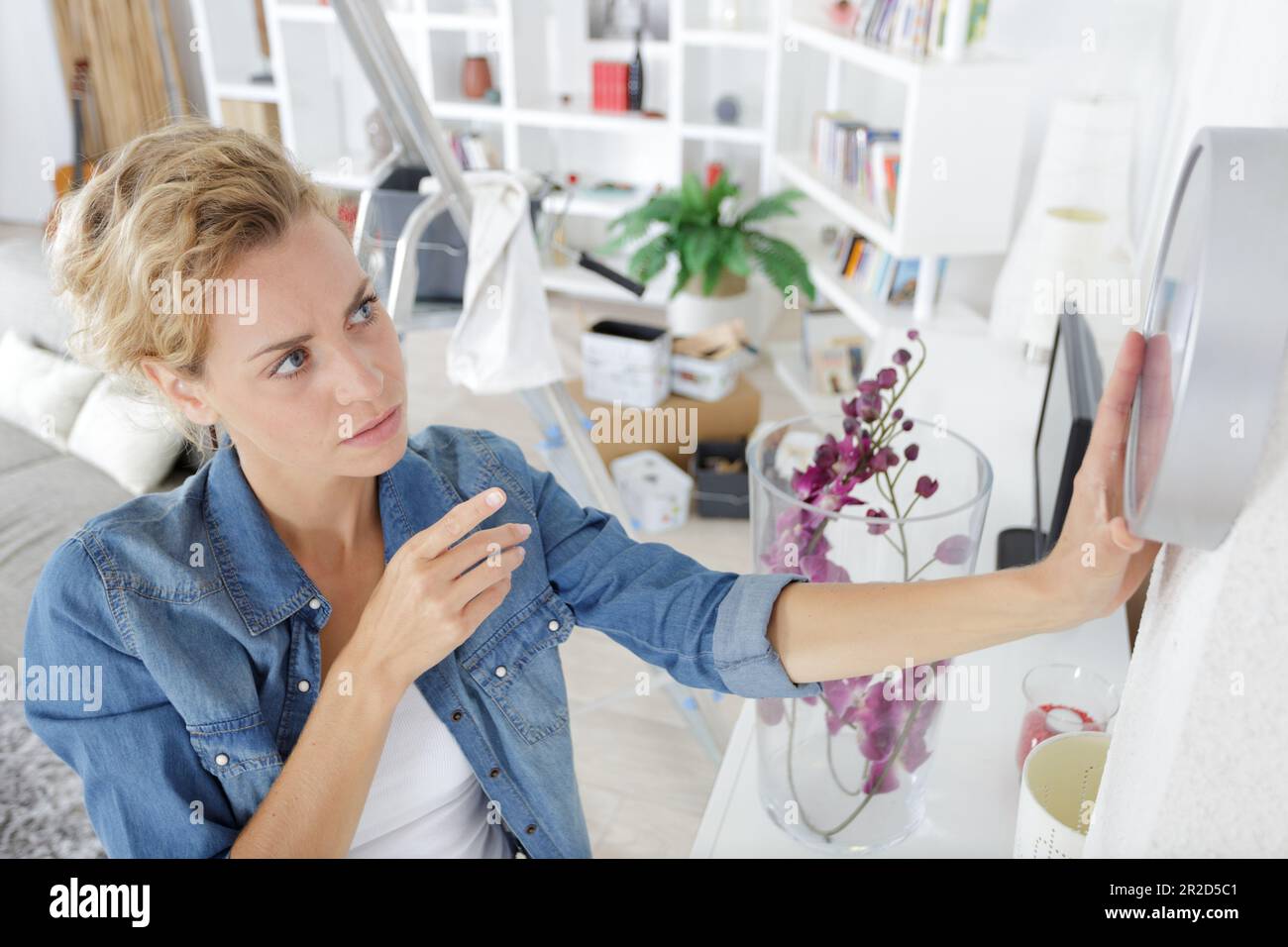 woman changing time on big wall clock Stock Photo