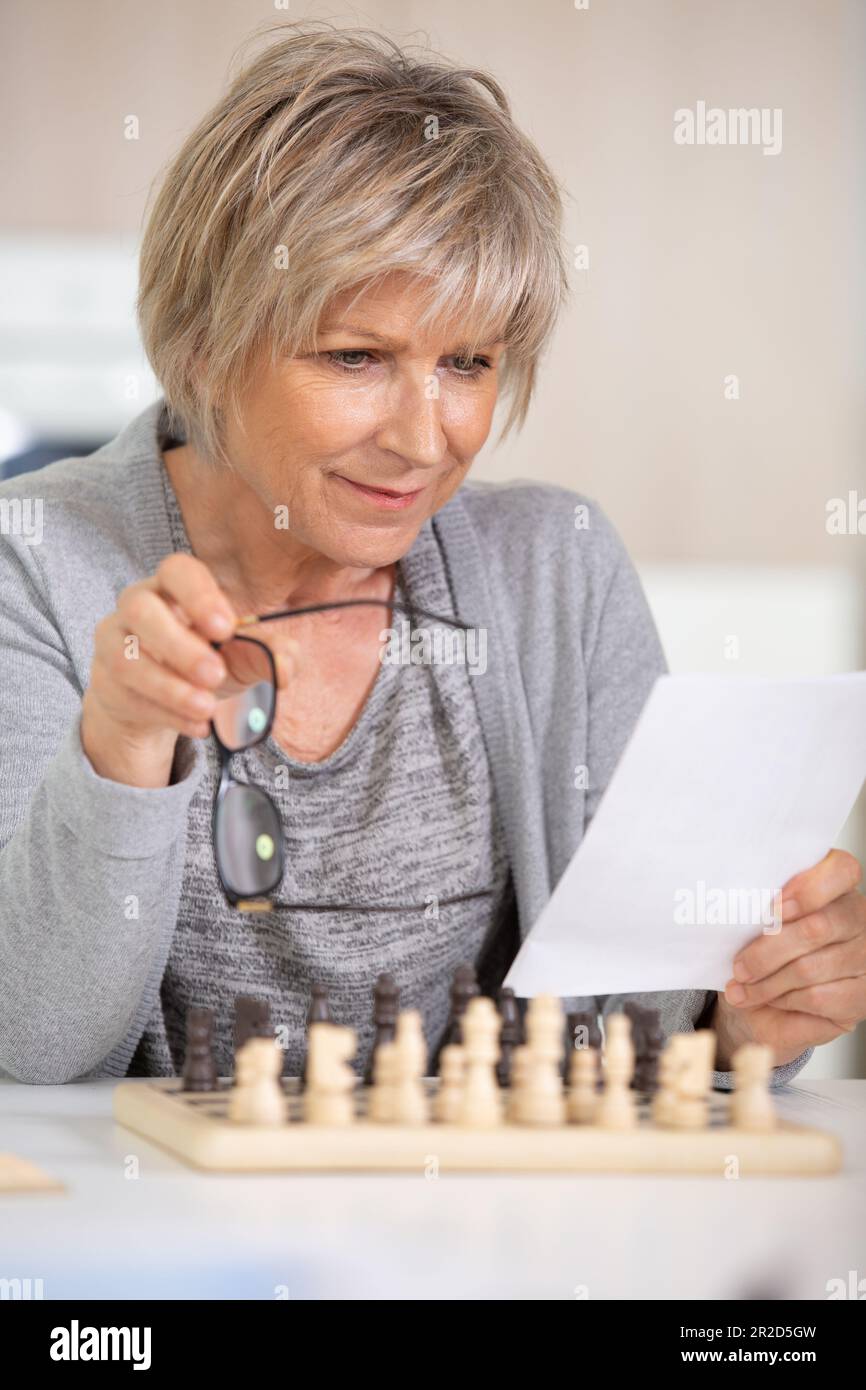 senior woman play chess at home Stock Photo