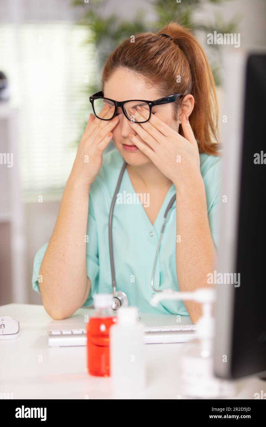 desperate female doctor sitting at her office Stock Photo