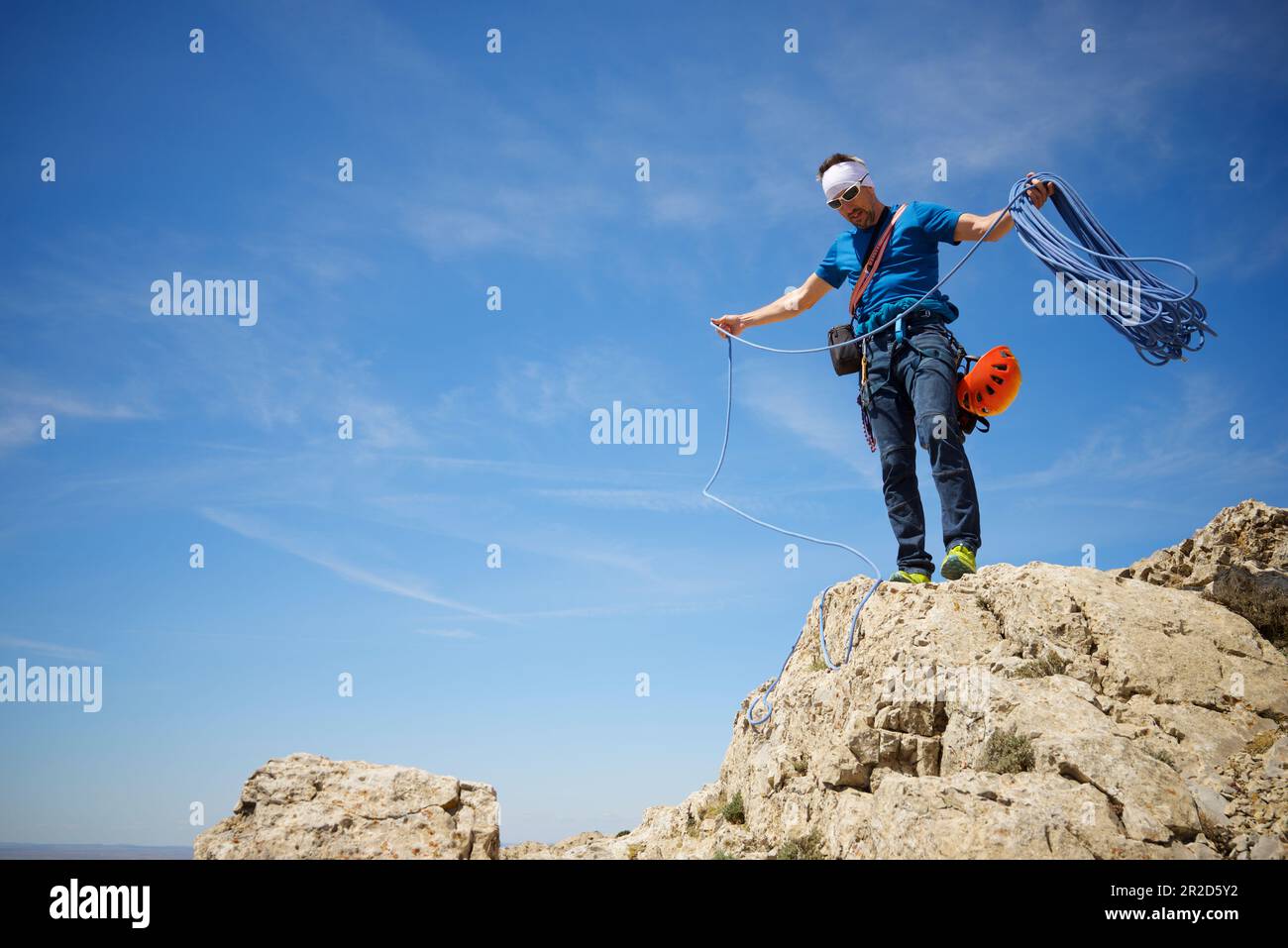 Climber picking up the rope at the summit of Palomera Peak. Stock Photo