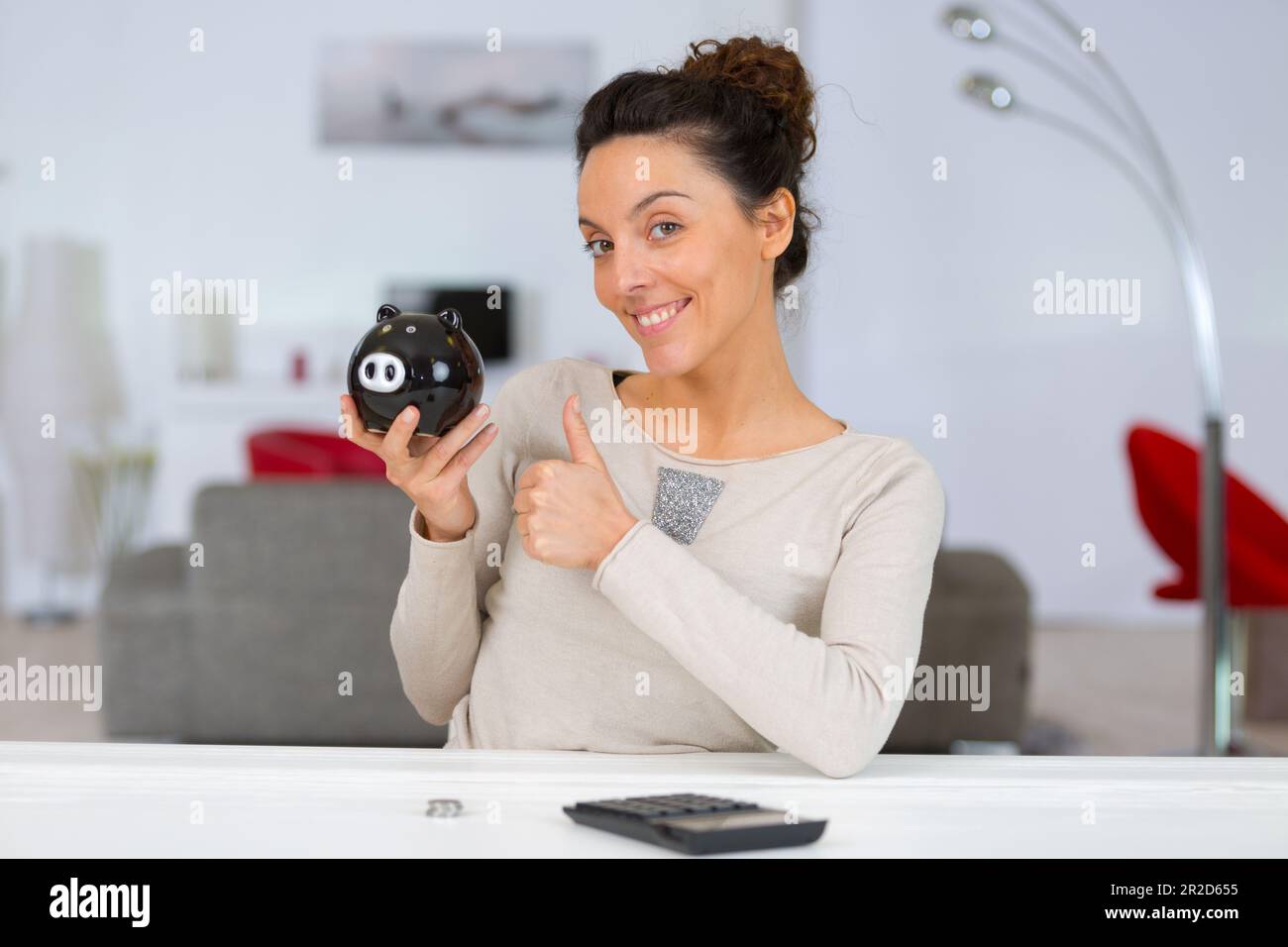 lady holding piggy bank and holding thumbs up Stock Photo - Alamy