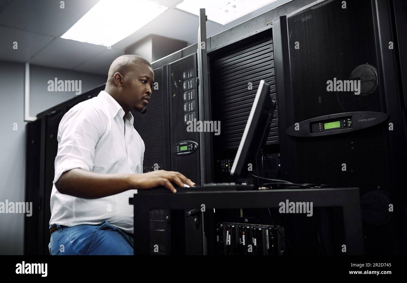 Engineer, black man or coding on laptop in server room for big data, network glitch or digital website. Code, IT support or technician typing on Stock Photo