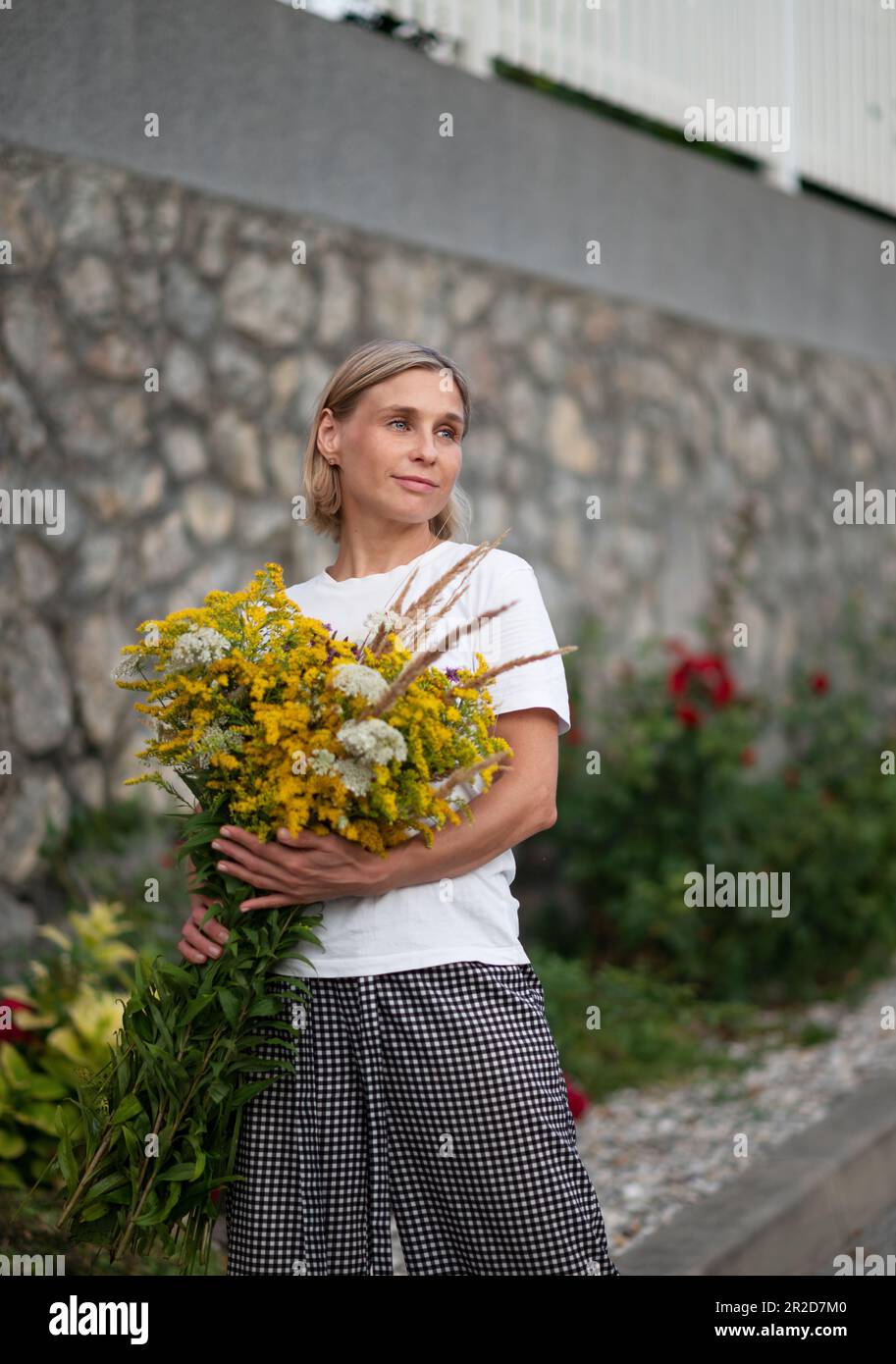 Portrait of a young blonde with a bouquet of wild flowers Stock Photo ...