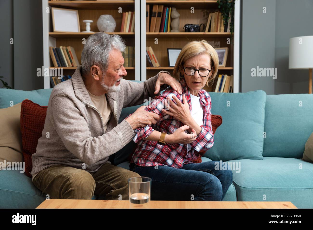 Portrait of senior couple in living room, Mature woman with pain in the