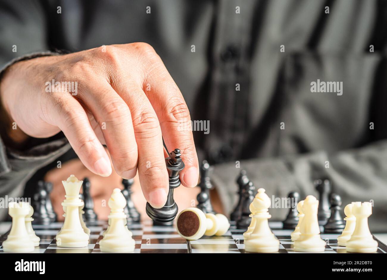 Premium Photo  Person playing chess board game, conceptual image of  businesswoman holding chess pieces against opponent chess against business  competition, planning business strategies to defeat business competitors