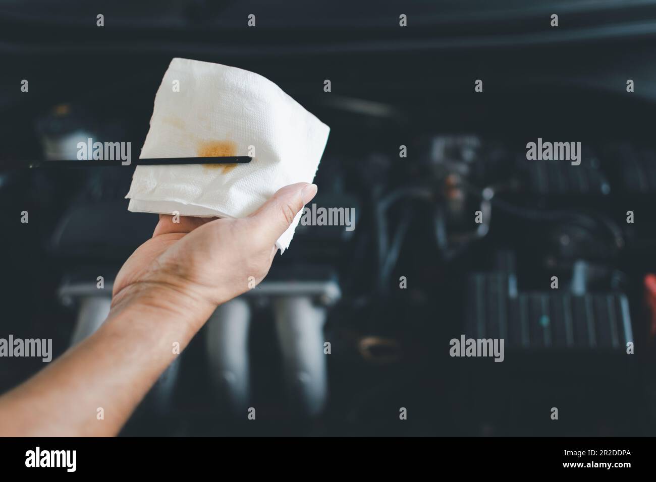 Man technician checks the oil from the dipstick. Checking the engine to ...