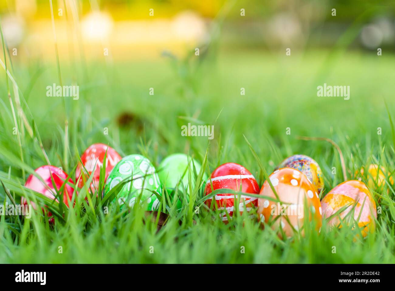 Abstract Defocused Easter, Closeup, many beautiful painted eggs as grass blurred background. concept for good friday, easter monday. copy space on top Stock Photo