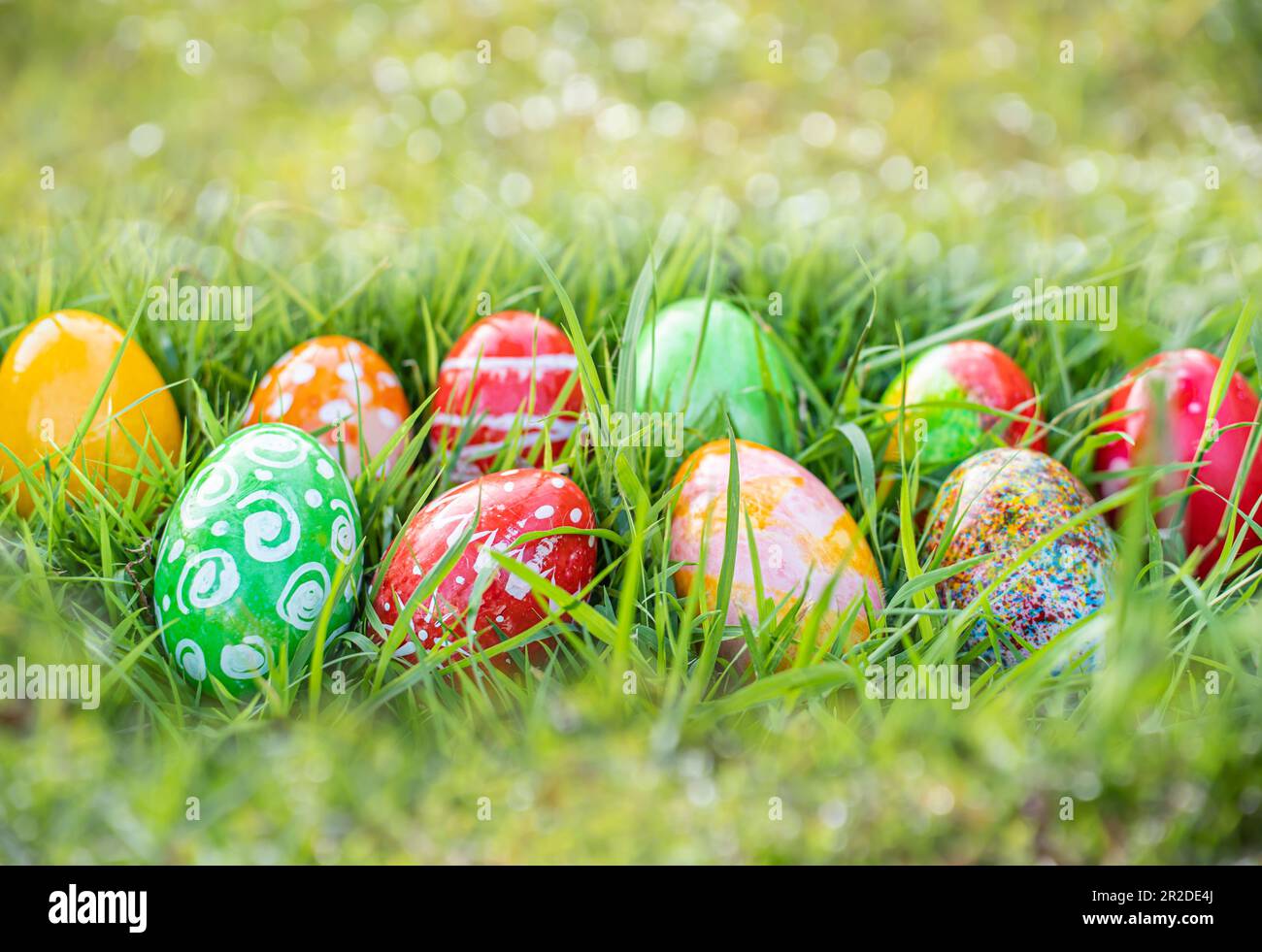 closeup, many beautiful painted easter eggs as grass blurred background. concept for good friday, easter monday, spring full moon. copy space on top f Stock Photo