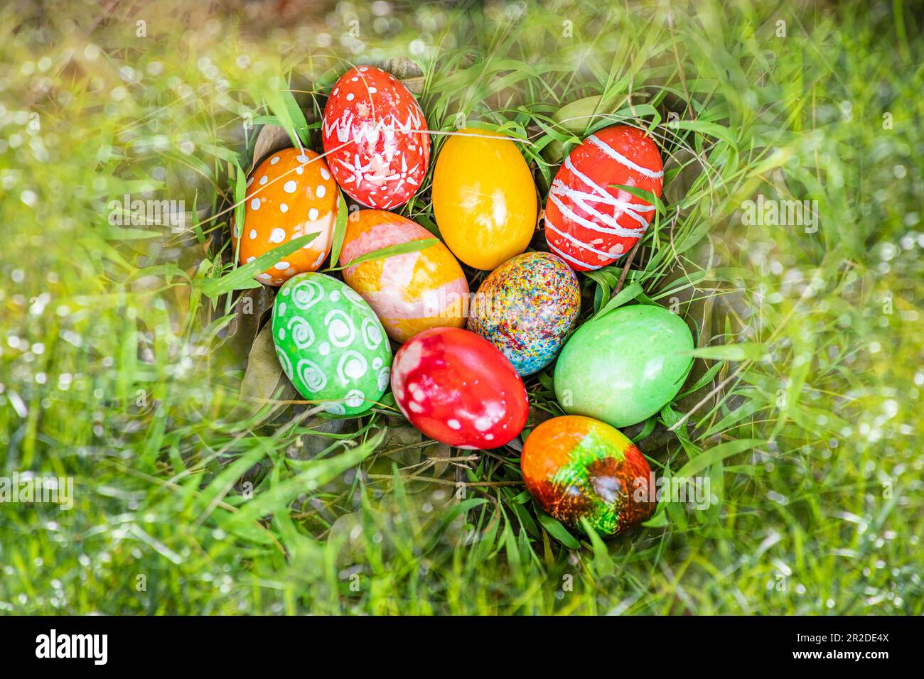 closeup, many beautiful painted easter eggs as grass blurred background. concept for good friday, easter monday, spring full moon. copy space on top f Stock Photo