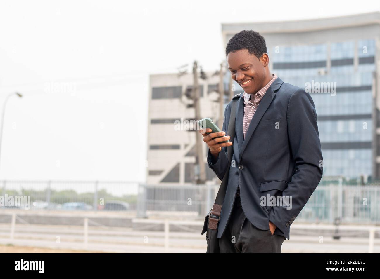 young african businessman smiling while using phone Stock Photo